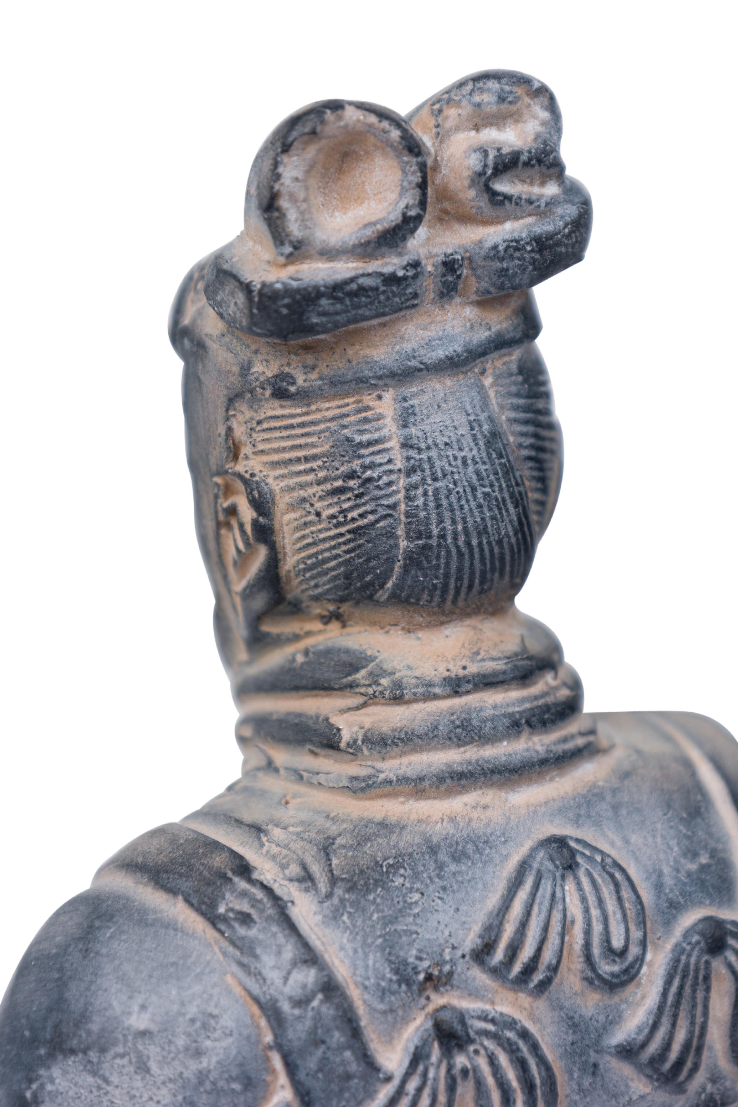 Chinese molded ceramic figure, fired in a matte gray finish, depicts a mustached dignitary in formal attire standing on a square base with both hands clasped.
 

 Some chipping with a prominent one on the right shoulder

