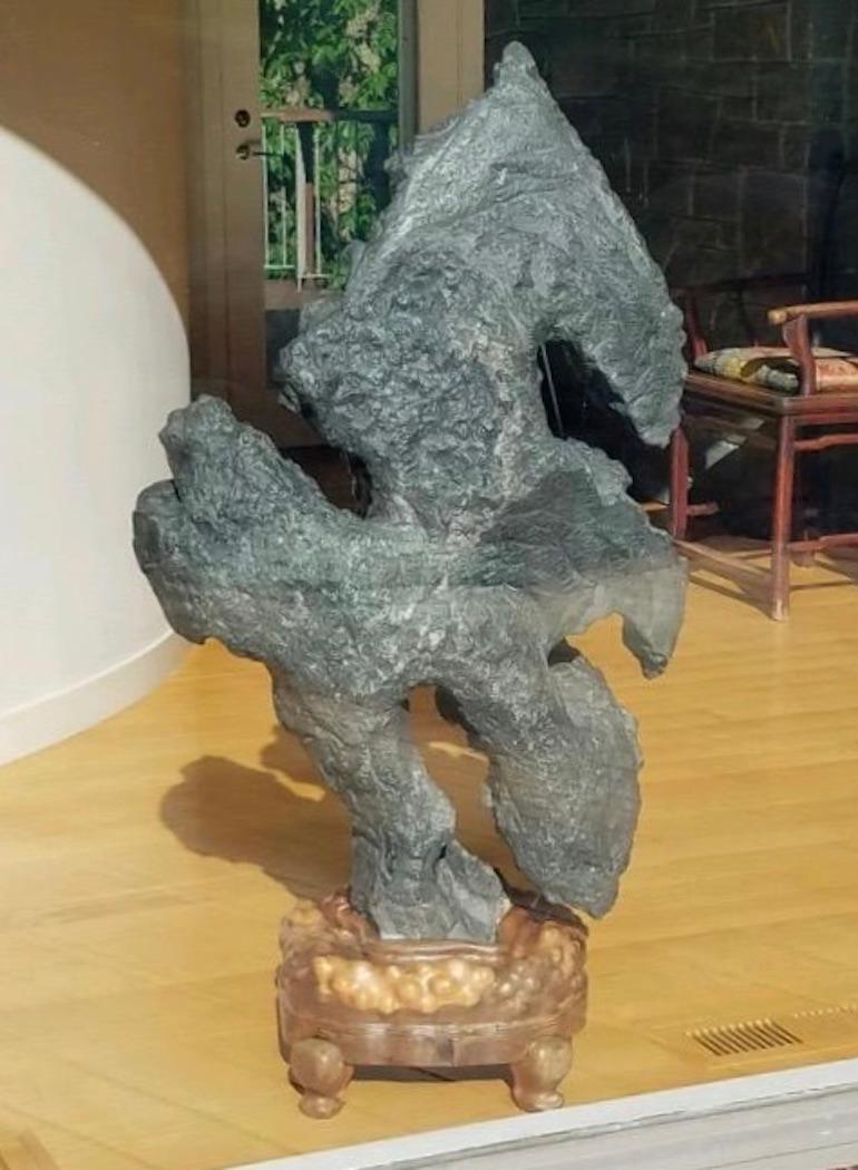 Chinese Gray Scholar's Rock, of naturalistic form, on early 19th century rosewood stand.