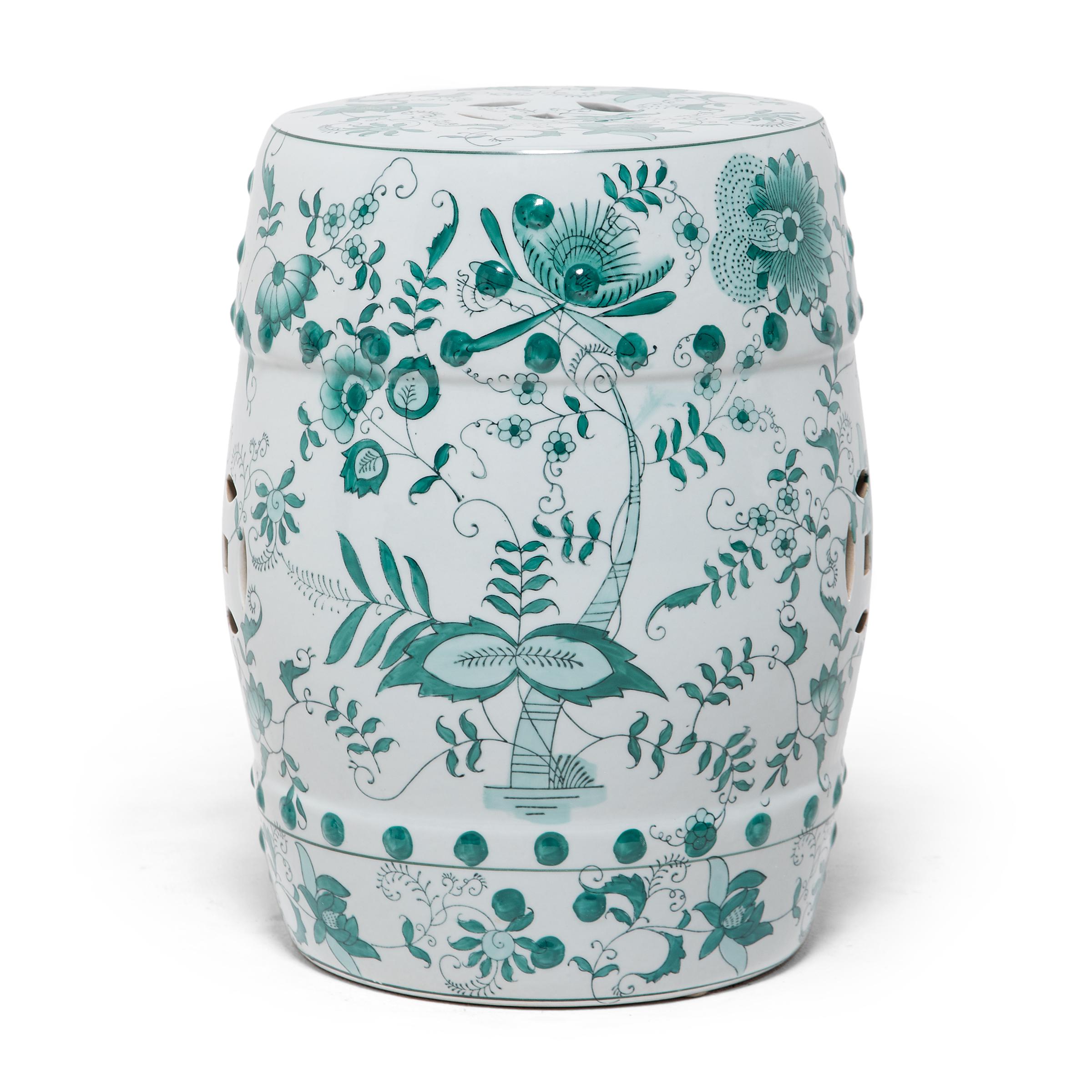 This charming porcelain garden stool is shaped in the traditional barrel drum form and patterned with an imaginative green-and-white floral design. The stool is painted with stylized peonies, plum blossoms, and lotus buds, each linked by delicate