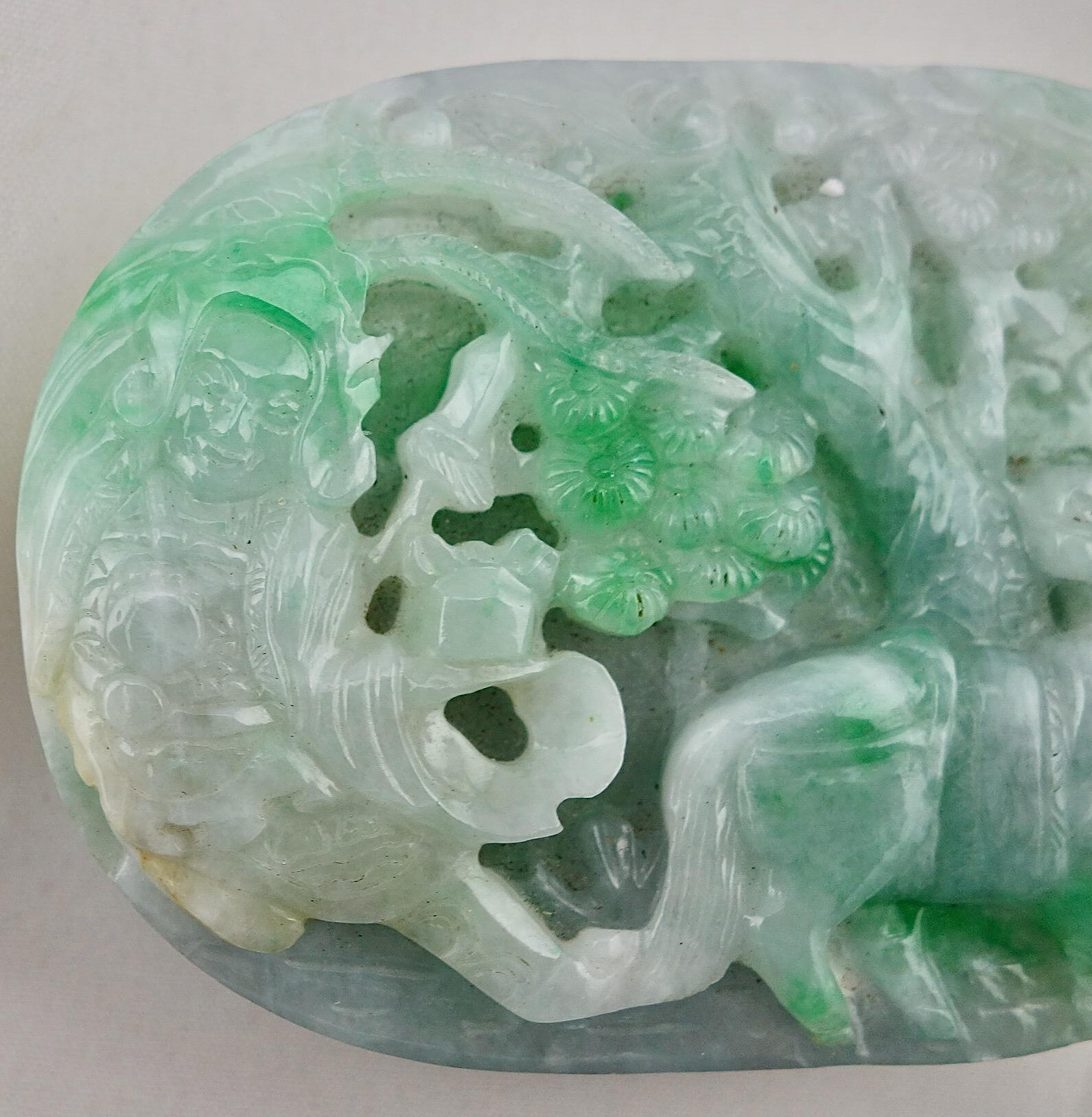 Chinese green and white jade hand carved high relief belt buckle, 19th century. The buckle depicts a maiden under a tree, and a horse in high relief. Obverse covered with scroll designs. The buckle is 2 1/2
