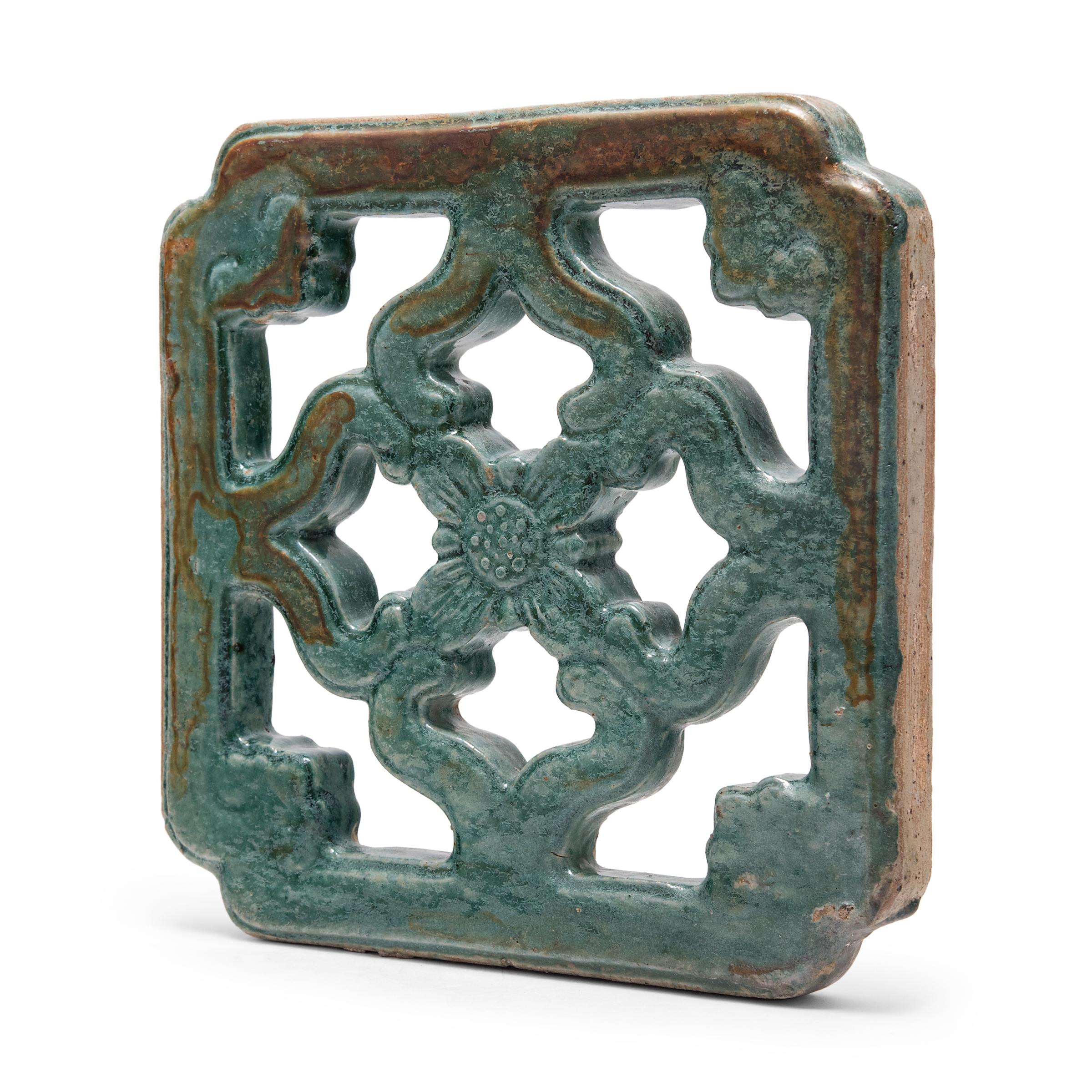 This early 20th century breezeway tile has a simple floral lattice design with cloud-like ruyi symbols at each corner. A beautiful turquoise-green glaze cloaks the exterior, textured by crazing, blisters, and iron leaching for wabi-sabi appeal. Much