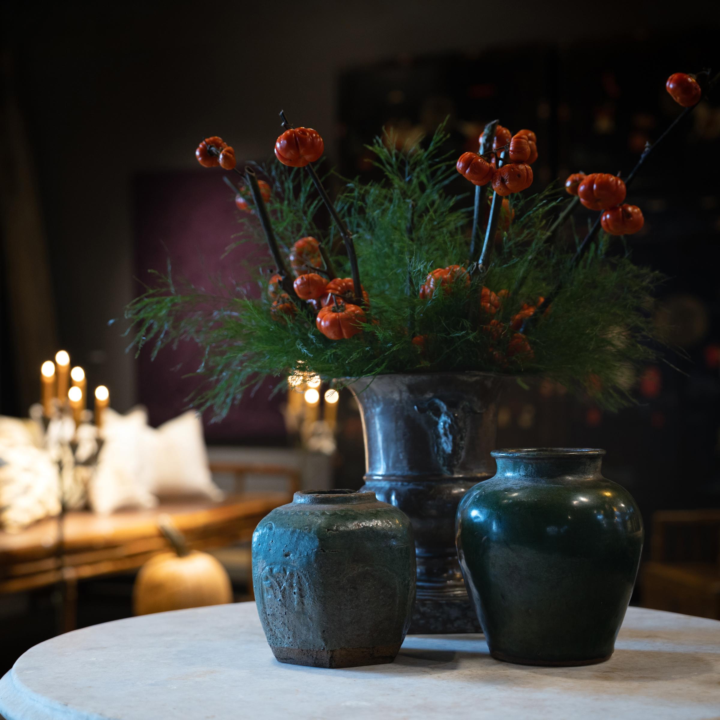 A lustrous glaze sheets across the paneled sides of this small Chinese storage jar, pooling into the low relief designs with deep, blue-green color. Sculpted in the early 19th century to store spices or kitchen goods, the earthenware jar has a