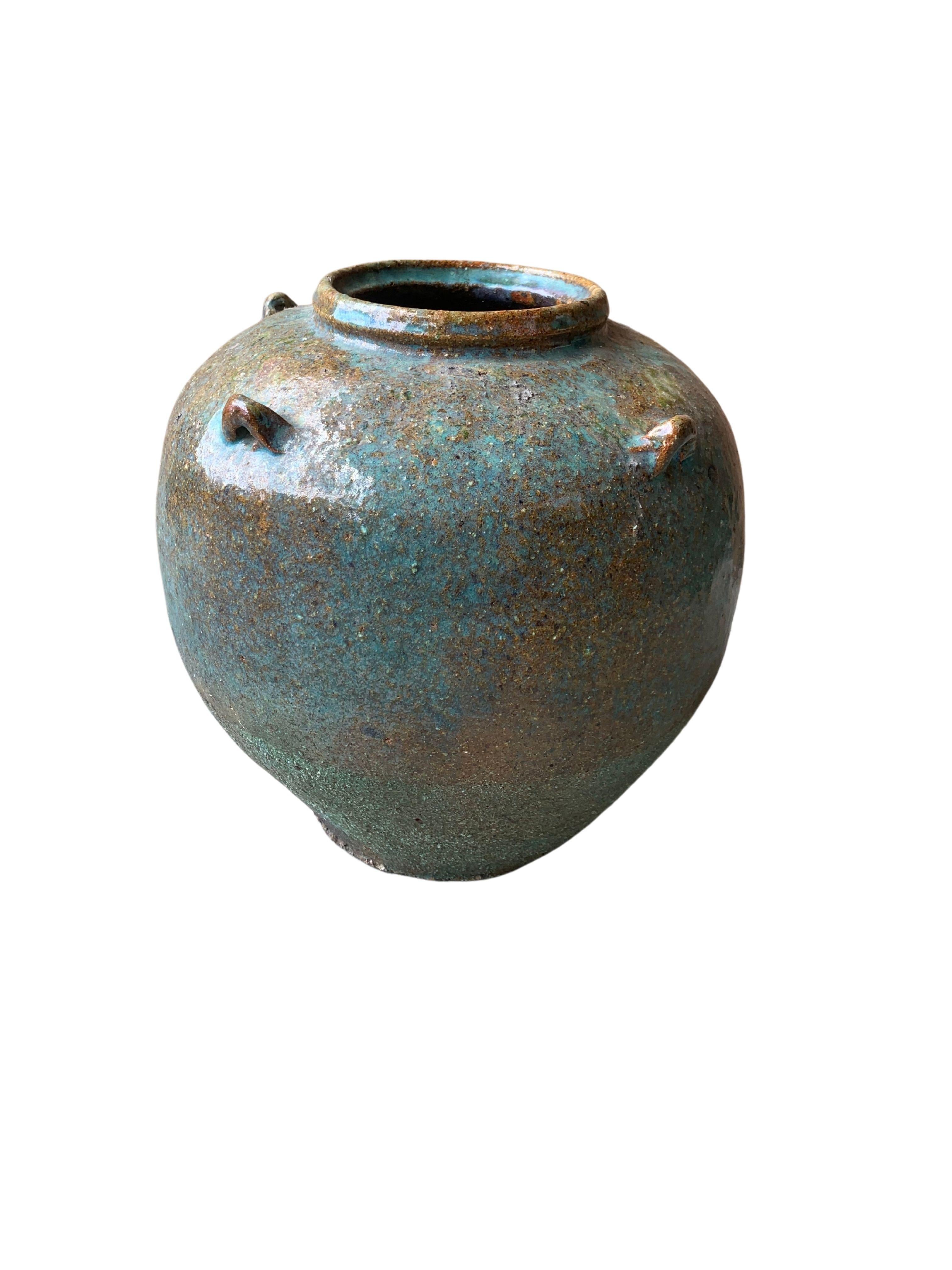 This Chinese ceramic jar dates to the mid 20th century and would've once served the purpose of storing food in the kitchen. The jars high shoulders and narrow base add to its charm. As well as the wonderfully mix of pigmented glazing the adorns its