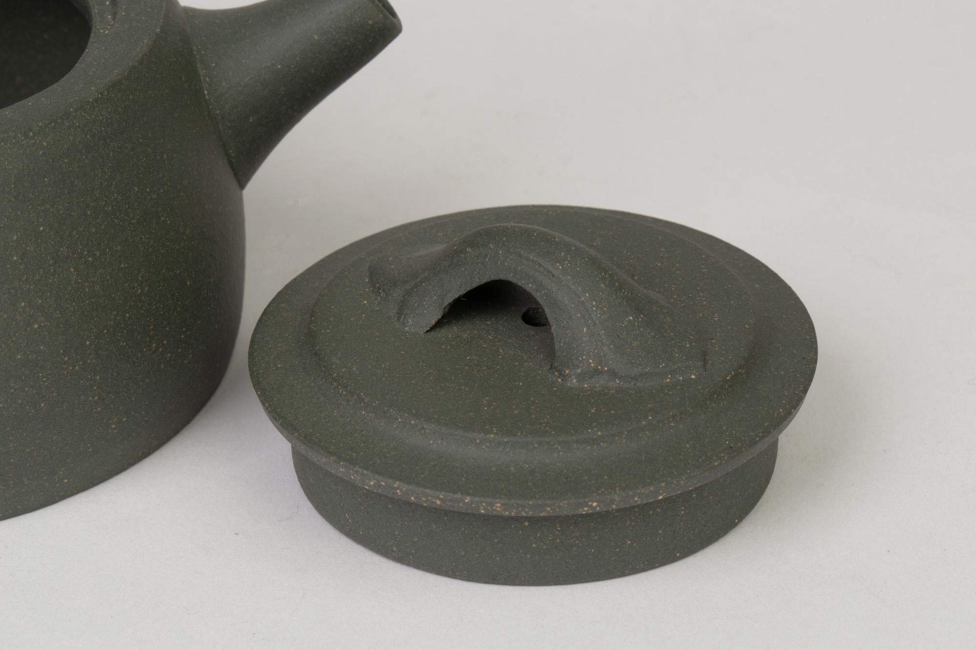 A very fine quality Chinese Yixing teapot and cover in green colored clay with paper certificate dating from the 20th century. The teapot is of simple squat rounded shape with loop handle and short rounded pouring spout and with a recess fitted