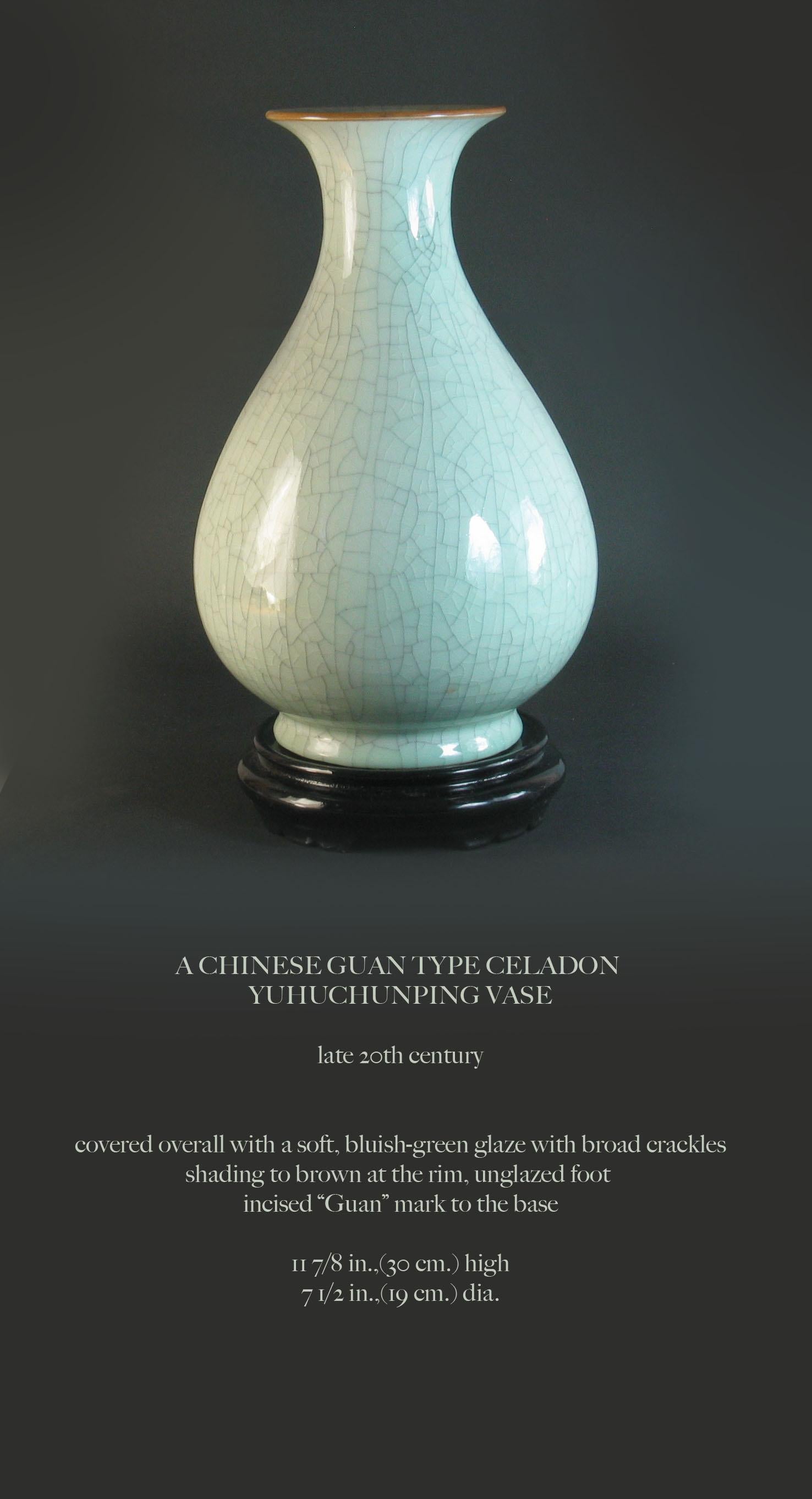 A Chinese guan type celadon
Yuhuchunping vase,

Late 20th century.


Covered overall with a soft, bluish-green glaze with broad crackles,
shading to brown at the rim, unglazed foot 
incised “Guan” mark to the base.

Measures: 11 7/8