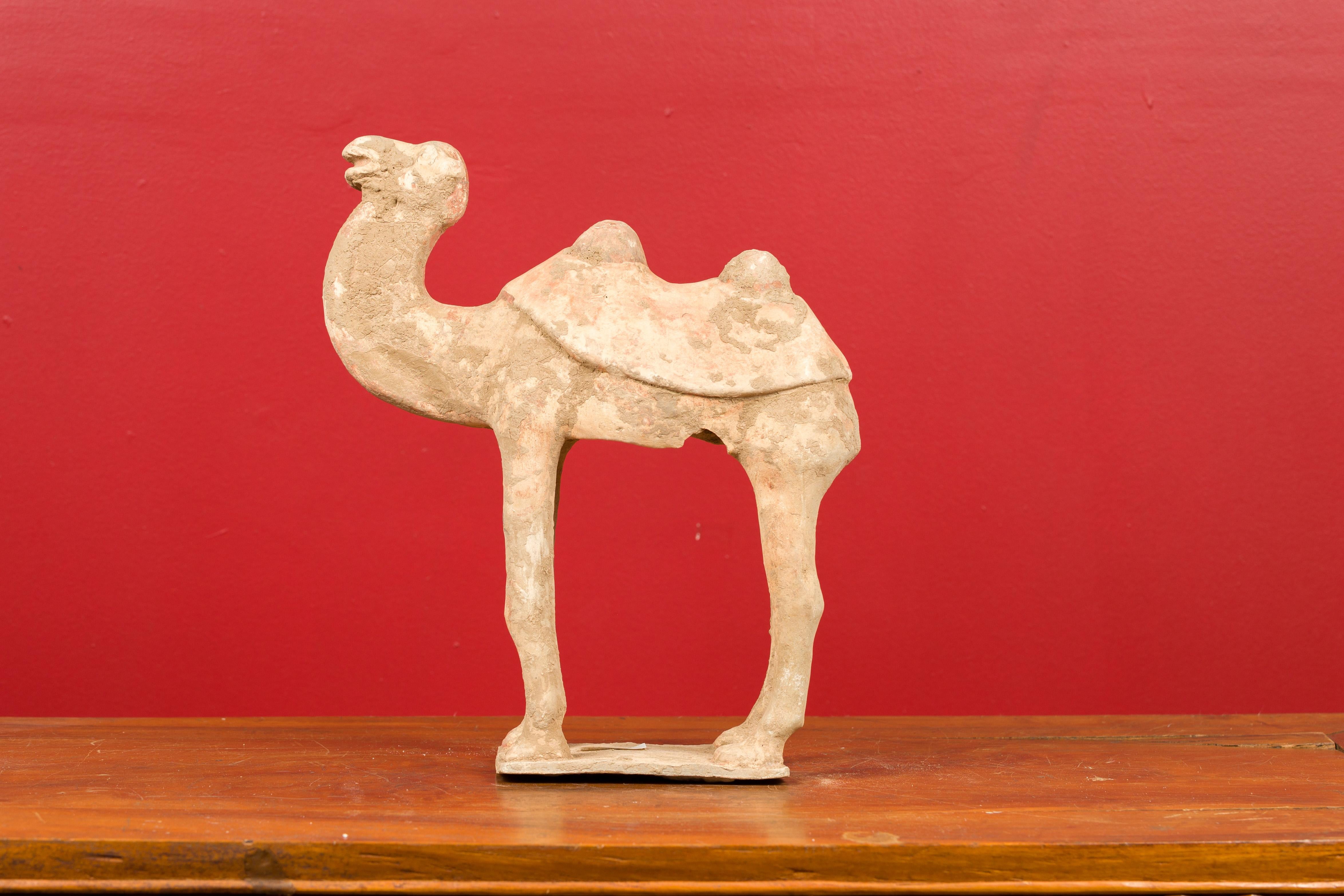 A Chinese Han Dynasty period mingqi terracotta camel circa 202 BC-200 AD, with traces of original orange paint fragments. Created in China during the Han Dynasty, this mingqi, a funerary statue created to be buried with the deceased to secure an