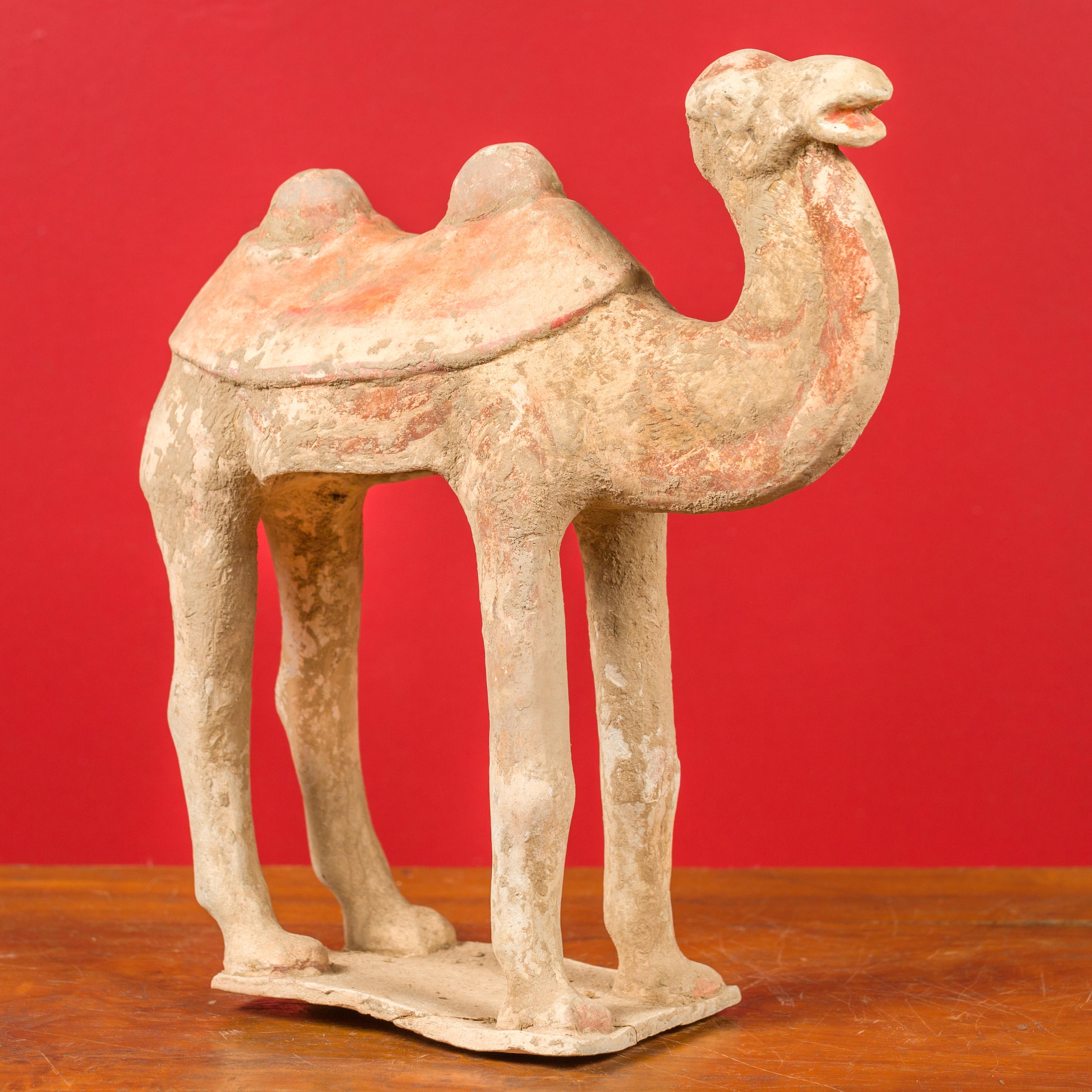 A Chinese Han Dynasty period mingqi terracotta camel circa 202 BC-200 AD, with traces of original polychromy. Created in China during the Han Dynasty, this mingqi, a funerary statue created to be buried with the deceased to secure an enjoyable