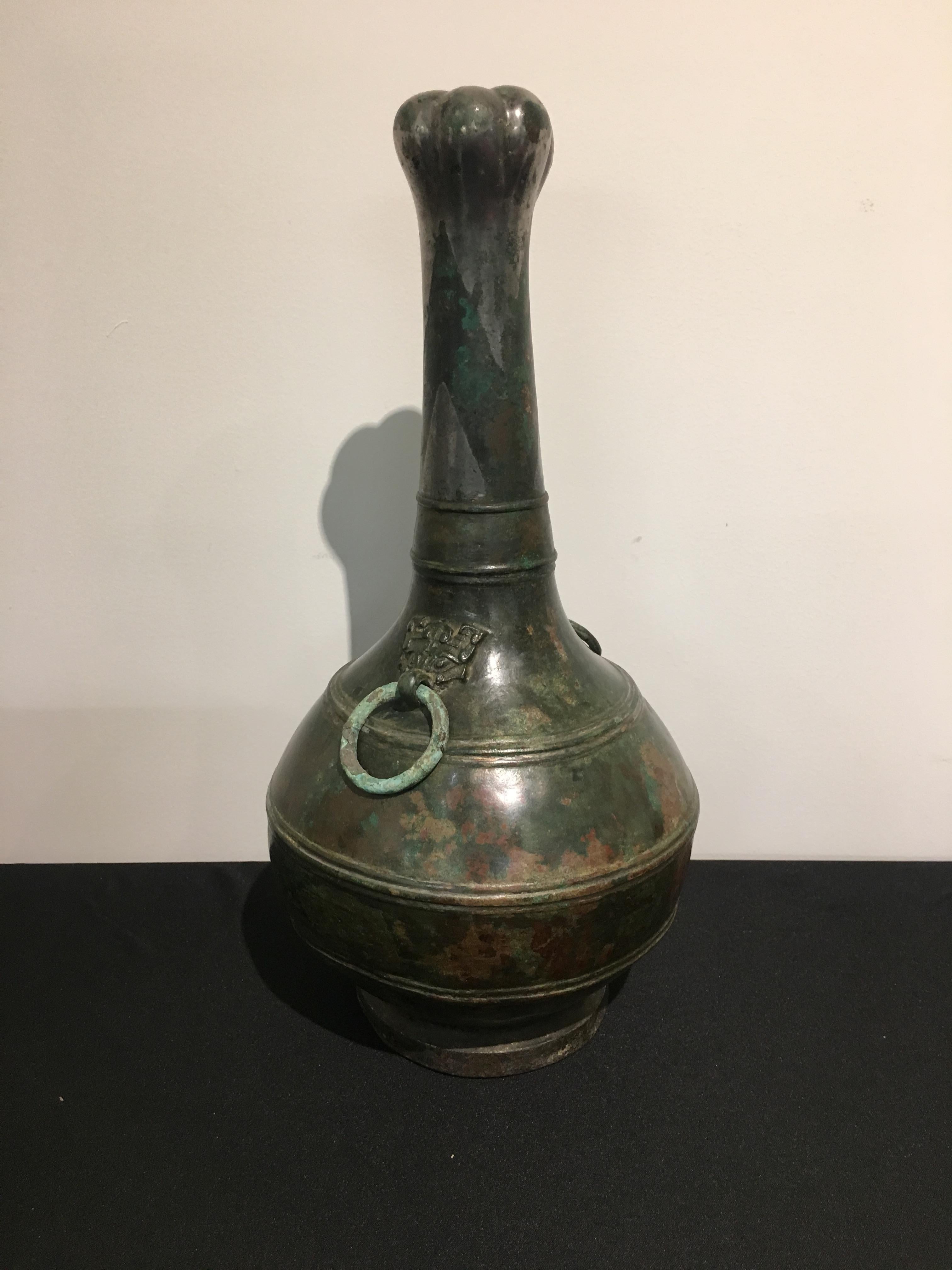 A gorgeous and striking late Warring States (475 to 221 BC) or early Han Dynasty (221 to 206 BC) cast bronze and silver-decorated garlic head hu vessel. 

Of elegant bottle form, with a beautiful rounded body and elongated neck topped by a garlic