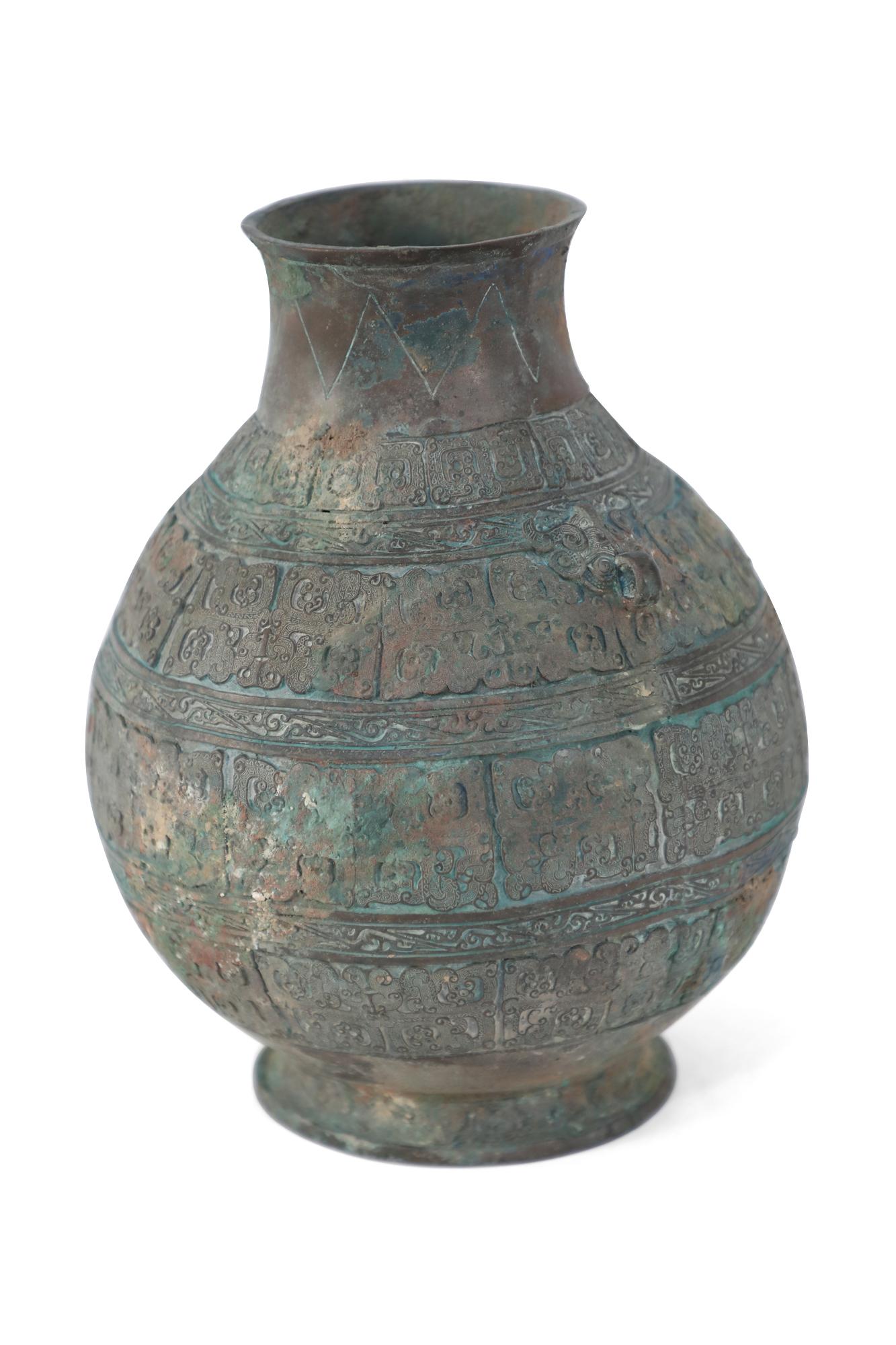 Antique Chinese Han Dynasty-style copy patinaed bronze urn carved with raised geometric patterned bands wrapping its form and adorned with two small handles beneath the neck.