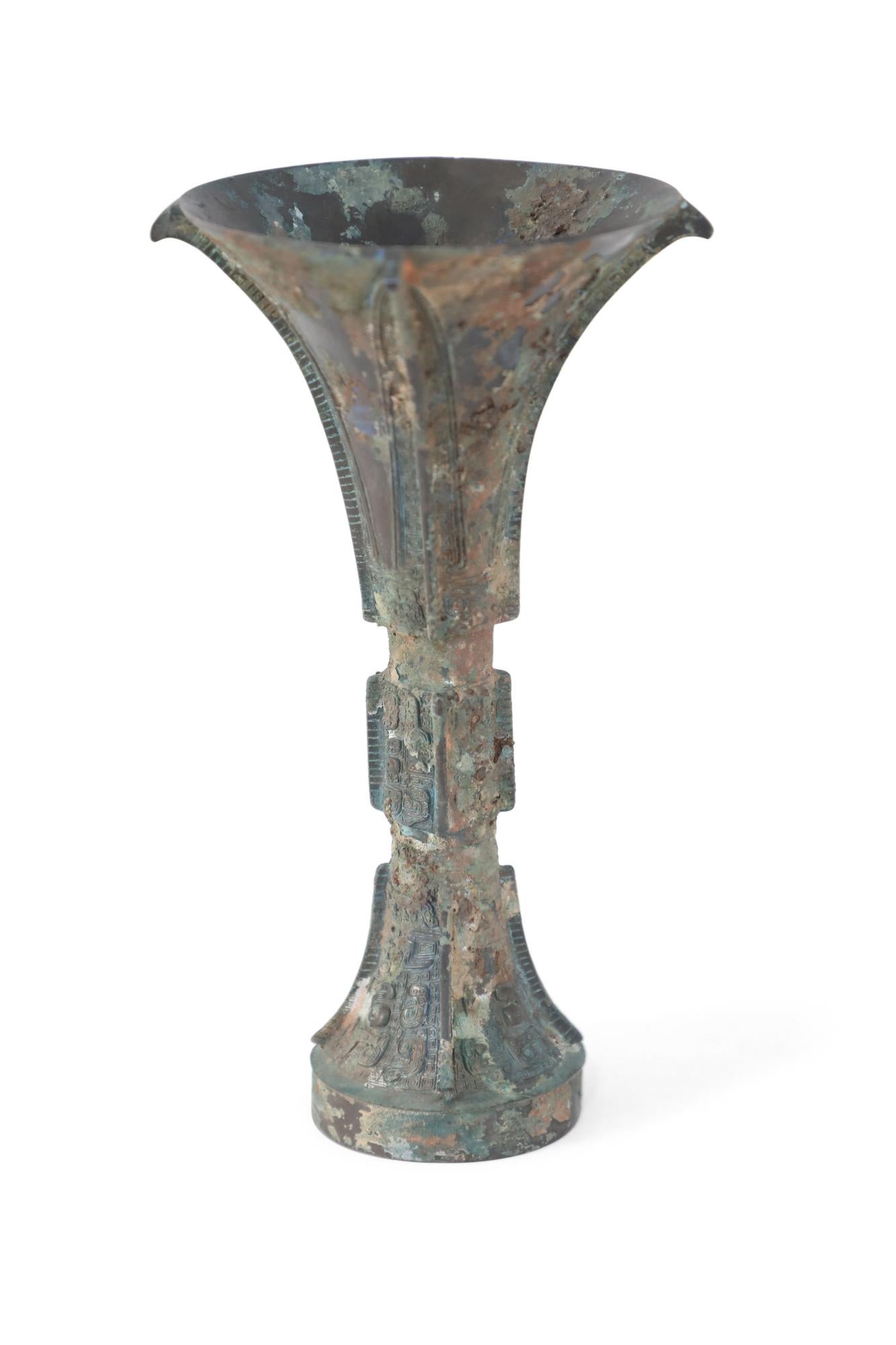 Antique Chinese Han Dynasty-style copy of a patinated bronze wine goblet with a fluted, conical form carved in intricate designs running up the surface, intercepted by two indented bands.

Condition: Good; Wear consistent with age and use