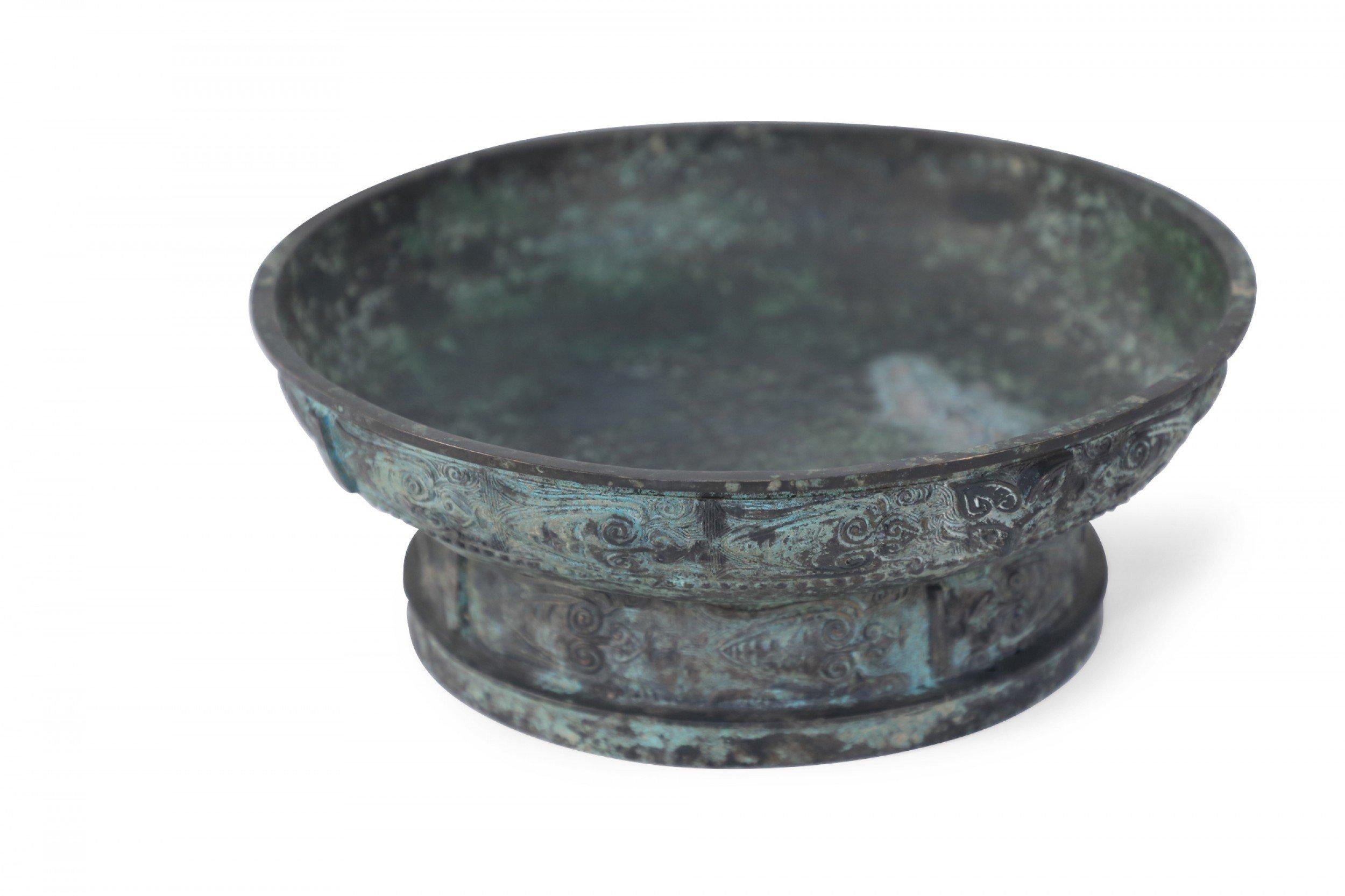 Antique Chinese Han Dynasty-style copy of a patinated bronze shallow bowl carved with raised geometric patterned bands wrapping the exterior, and an inscription on the bottom of the interior.