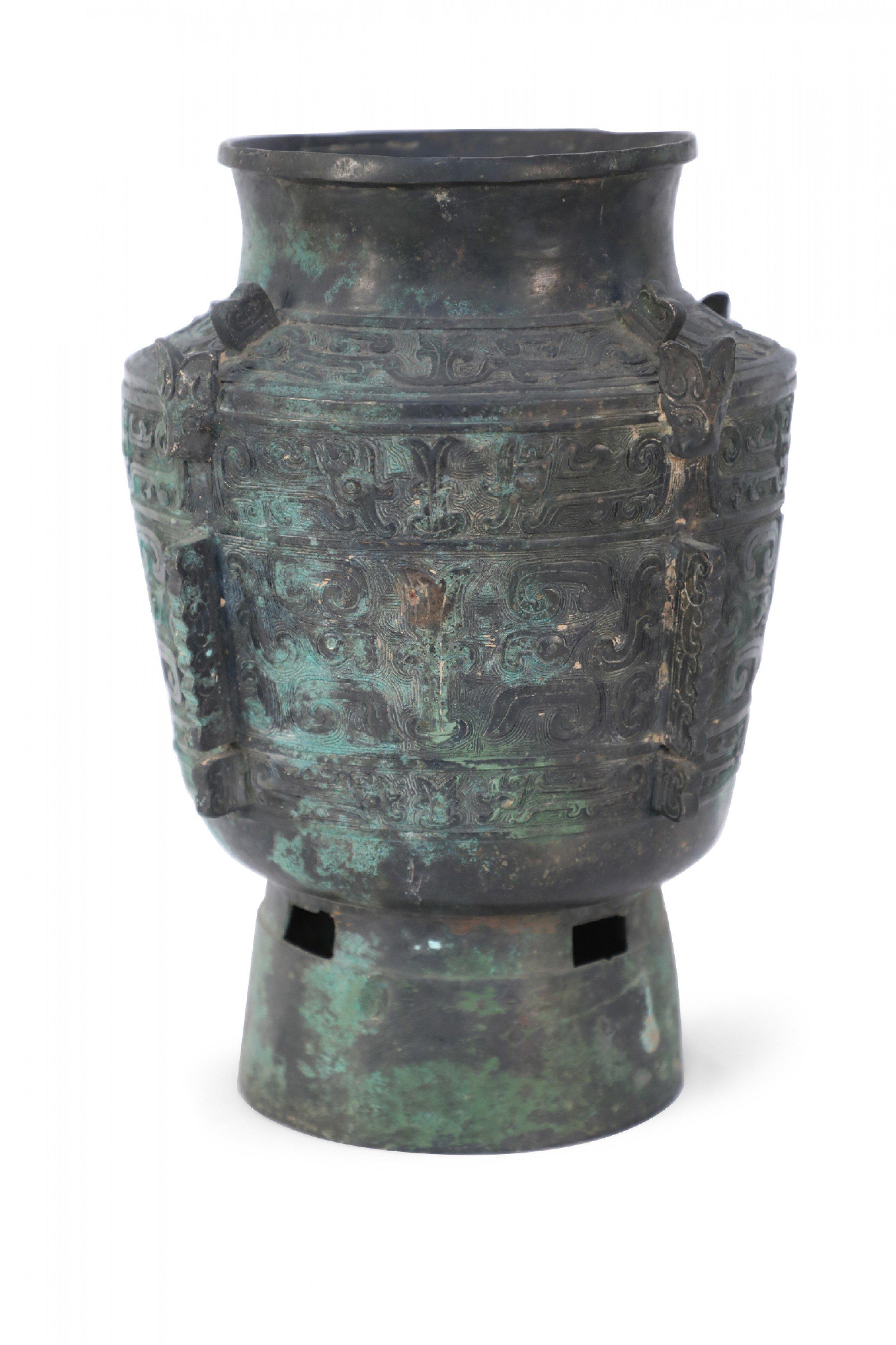 Antica copia in stile Dinastia Han cinese di un'urna conica in bronzo con patina verde e nera, decorata con motivi geometrici in rilievo e pezzi lineari intagliati che si estendono dal corpo su tutti i lati.