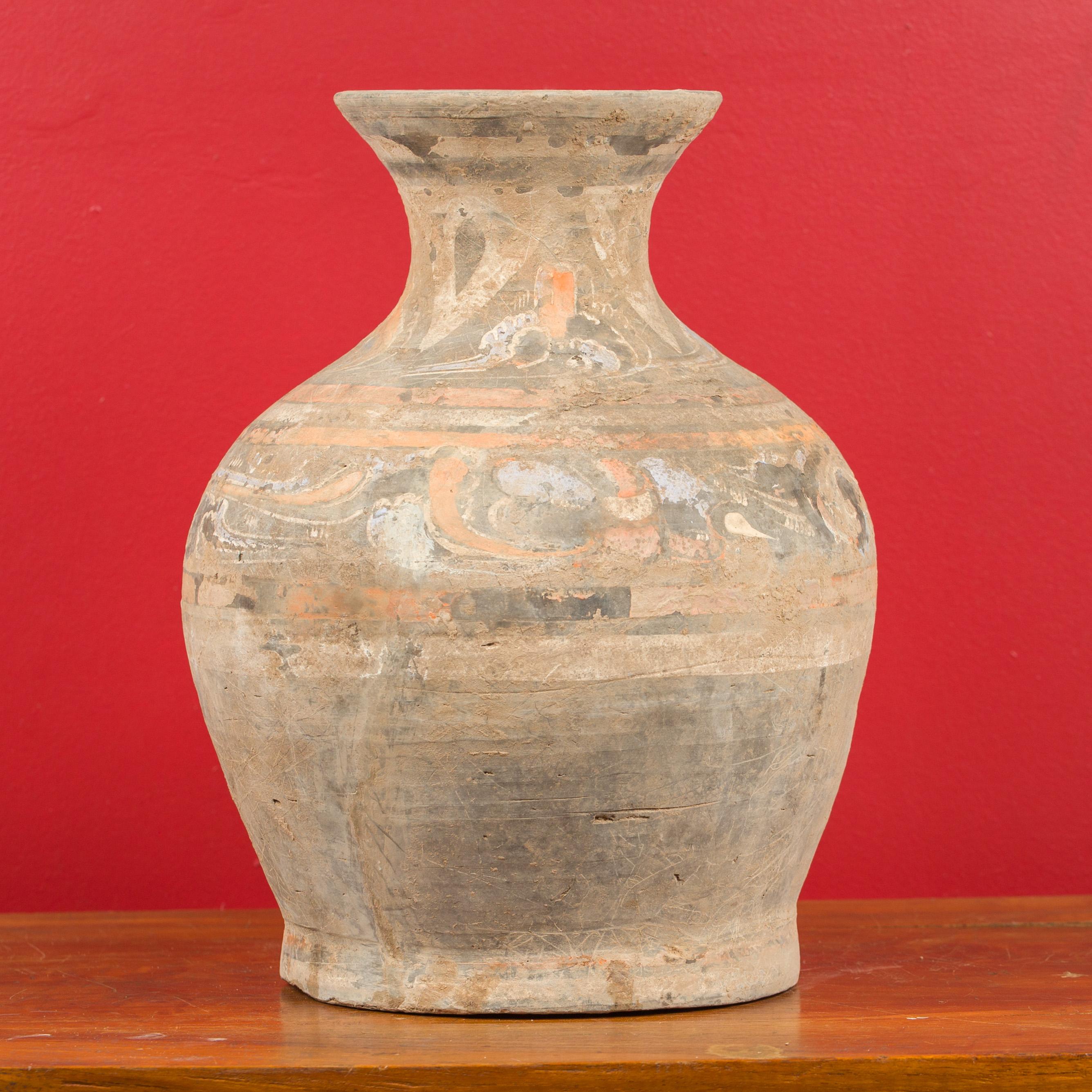 A Chinese Han dynasty terracotta Hu vessel circa 202 BC-200 AD, with original hand painted decor. Created in China during the Han dynasty, this terracotta wine vessel, called a Hu vessel, features a nicely swelling body topped with a narrow neck.
