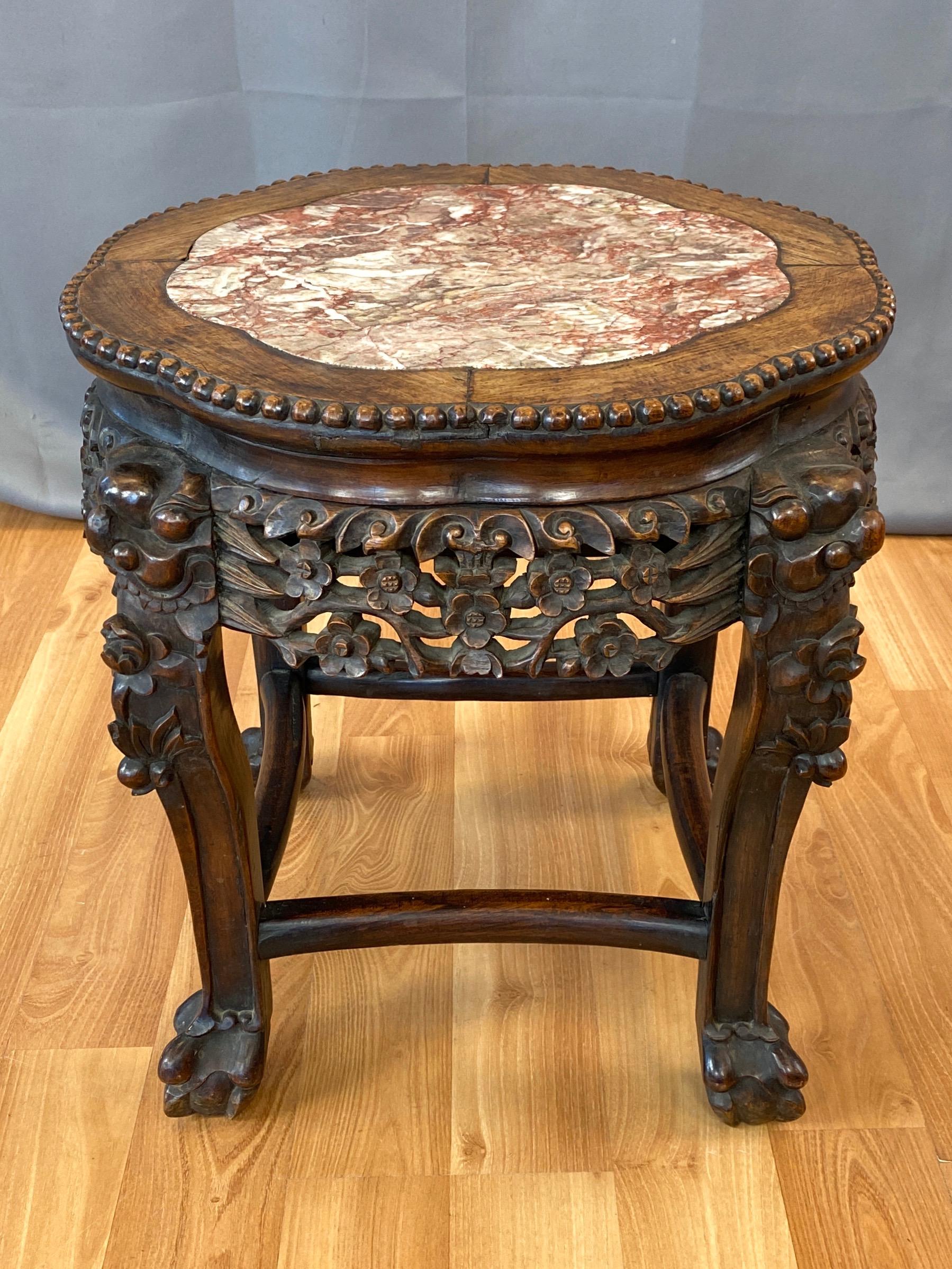 A very handsome circa 1900 Chinese hand carved huanghuali rosewood and marble plant stand, side table, or stool.

Endearingly stout form with finely executed traditional motifs on wonderful display throughout. Top with beaded edge above an open