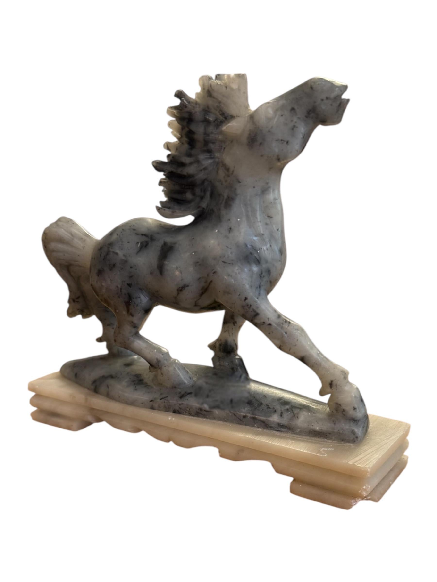 Graceful, spirited, and full of motion—this Chinese hand-carved jade marble horse sculpture captures the majestic beauty of the horse in mid-stride. Expertly sculpted from a natural blend of deep gray jade with subtle marble veining, the horse is