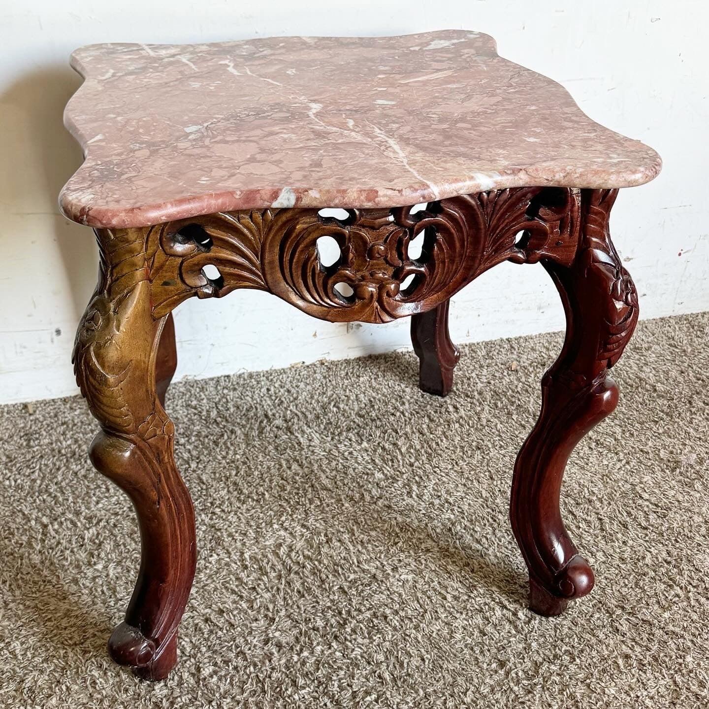 Ajoutez de l'élégance avec cette table chinoise en bois de rose sculpté et en marbre rose. Le socle en bois de rose sculpté à la main témoigne d'un travail artisanal complexe, complété par un luxueux plateau en marbre rose lisse. La forme courbée et