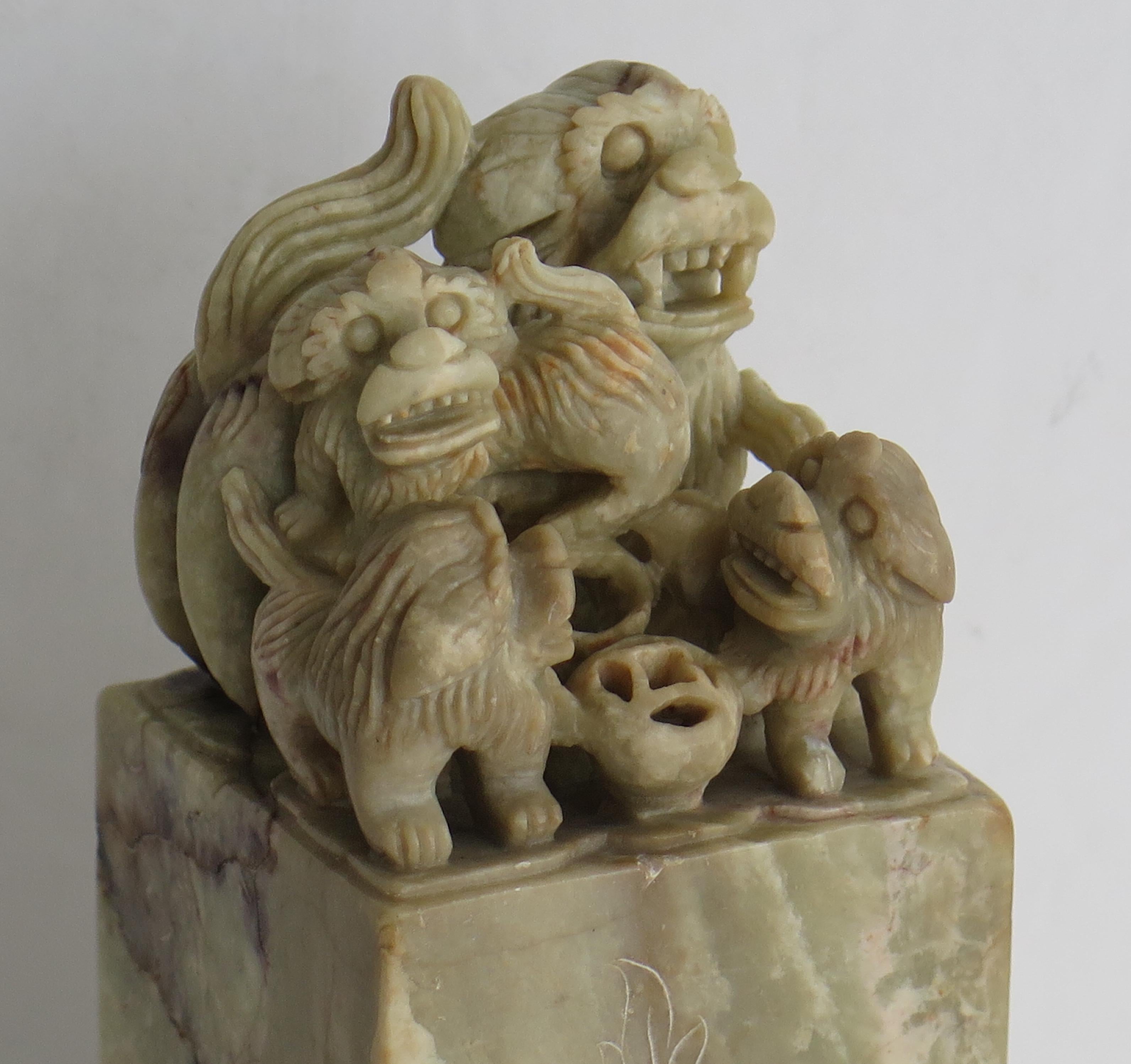 This is a good Chinese soapstone carving made in China during the 19th Century, Qing period.

The piece is shaped like a Chinese Seal, having a square vertical column with a hand carved group or family of Foo Dogs at the top of the column. Each of
