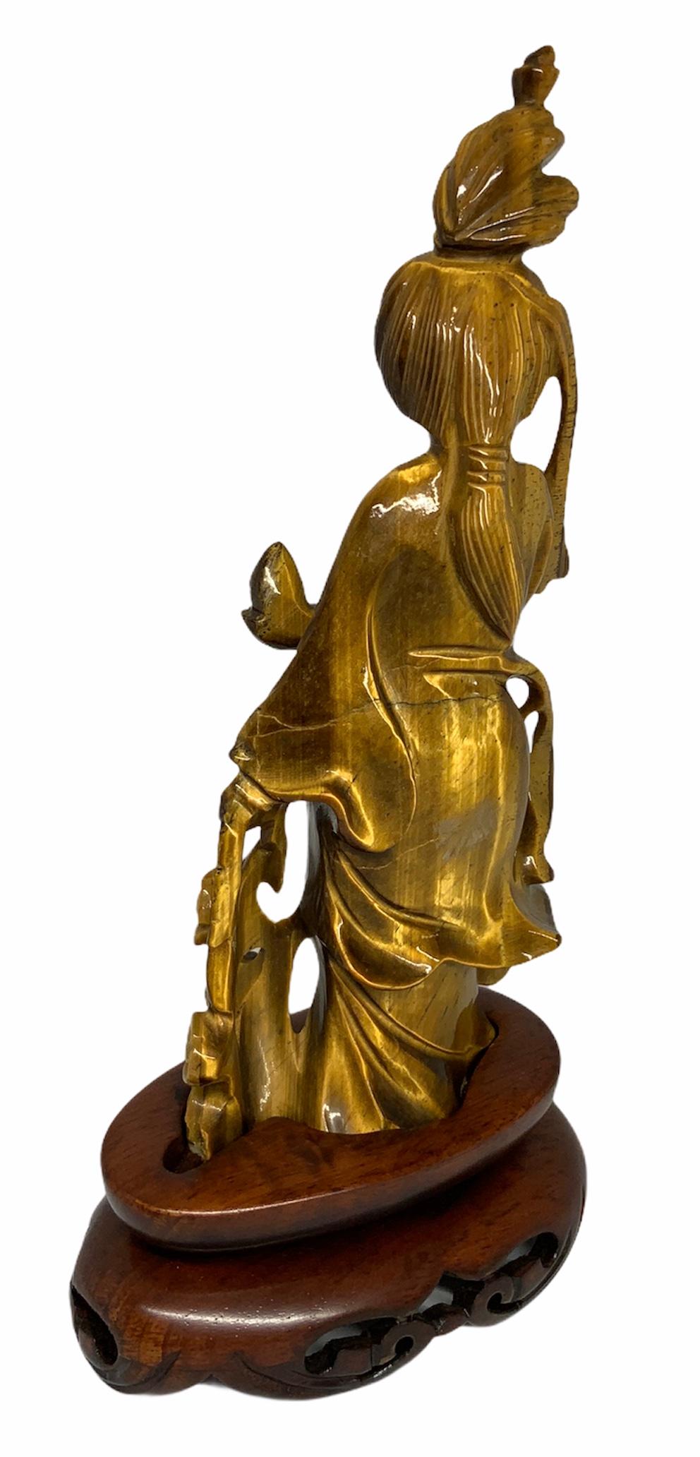 A small sculpture in tiger eye of Guan Yin holding a vase in her right hand and some branches of willow flowers in her left hand. In the Buddhism religion, the vase symbolize good fortune and contain the nectar of life. The willow branches are a