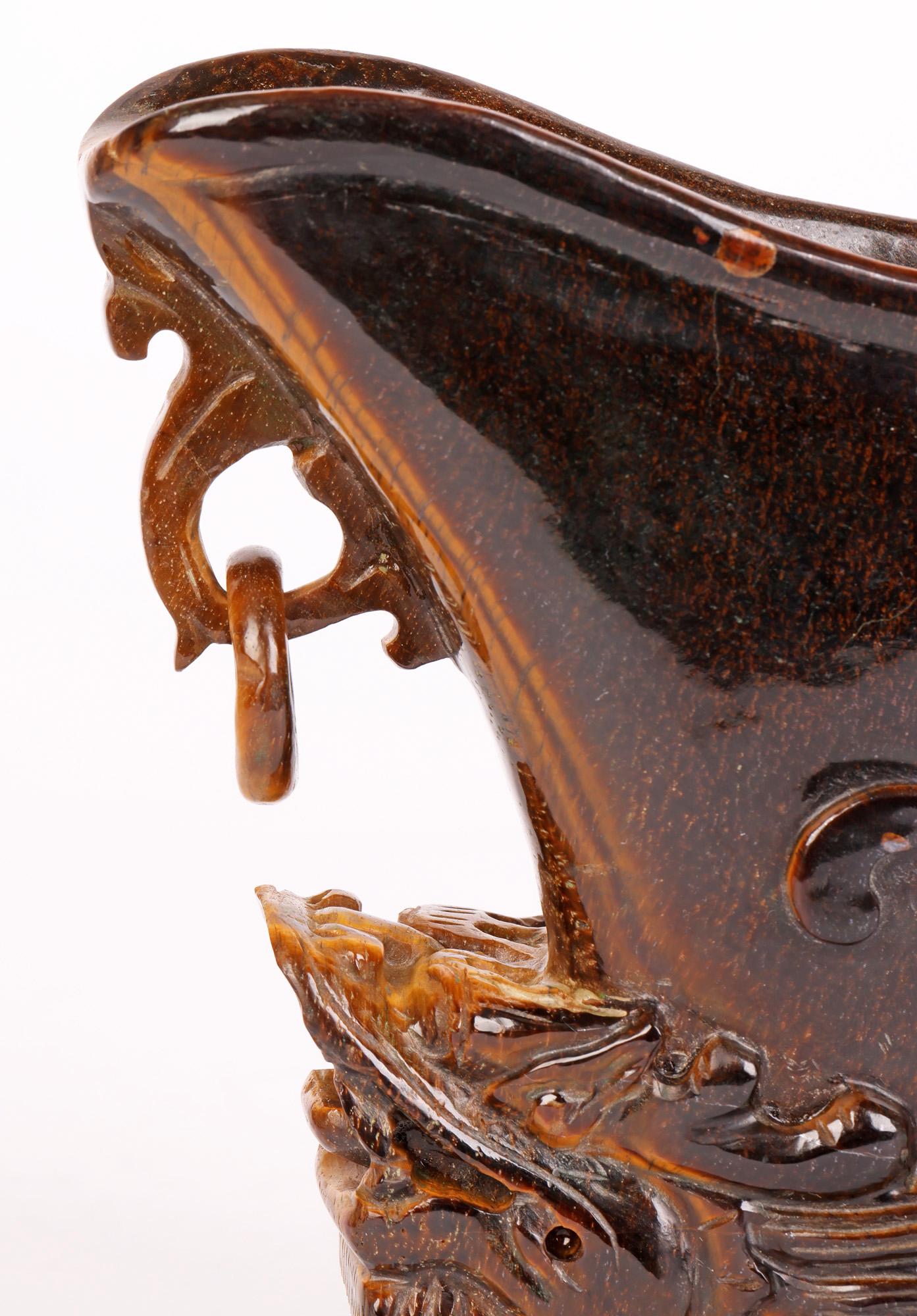 Eine feine antike/vintage chinesischen geschnitzten Tiger Auge Stein Trankopfer Tasse von einem Drachen unterstützt und aus dem frühen 20. Jahrhundert oder möglicherweise früher. Der Hartsteinbecher ist aus einem einzigen Stück Stein gemeißelt. Das