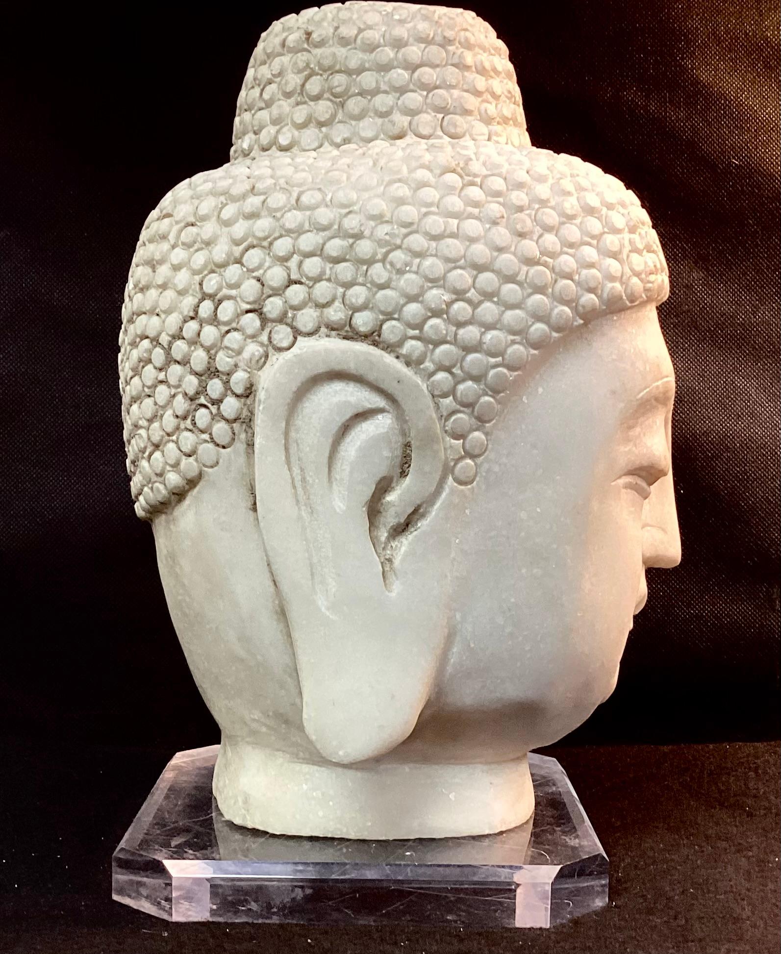 Chinese hand-carved white marble Buddha head. Heavy marble is in very good condition and is meticulously hand carved with a facial expression showing peace and tranquility. 