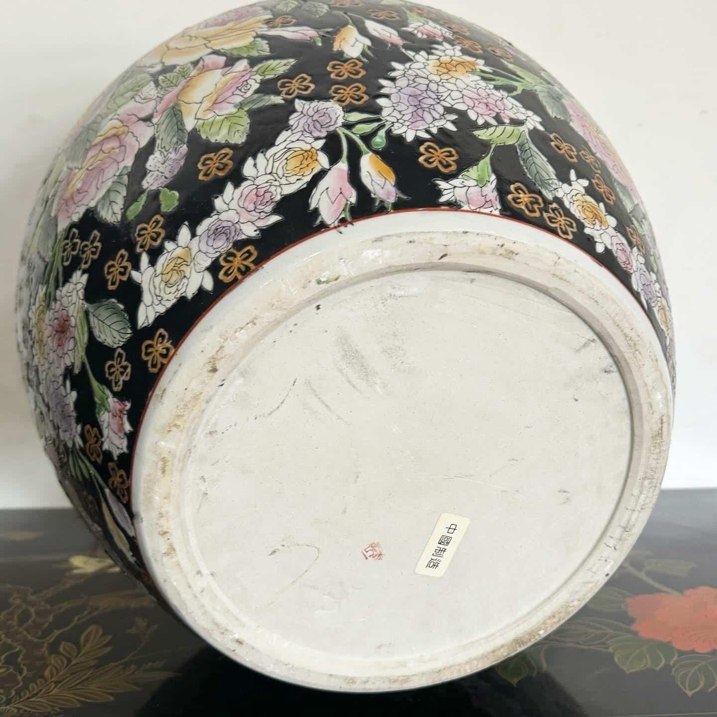 Ce vase à poisson exquis, peint à la main en Chine, présente des motifs floraux complexes dans des couleurs vibrantes. Le fond noir met en valeur les délicates fleurs pastel, ce qui en fait une superbe pièce décorative ou une jardinière. Reflétant