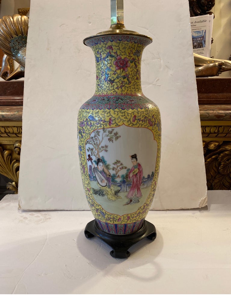A hand painted Chinese porcelain lamps with an imperial yellow background. The white porcelain with cartouches of aristocratic women in a floral background with intricately detailed all over decoration in yellow, pink, blue and aqua... The brass
