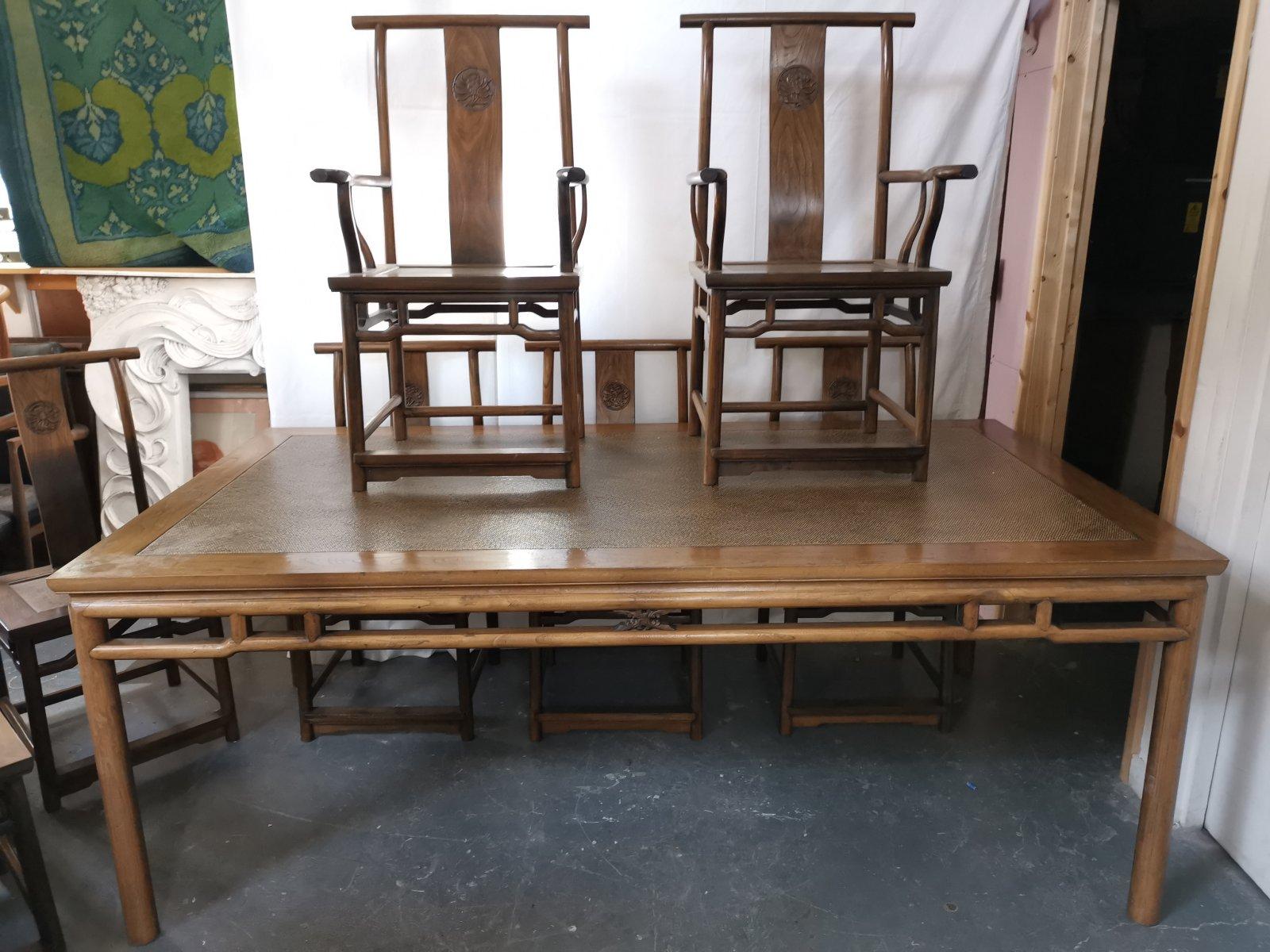 A super quality Chinese hardwood dining table, with eight matching chairs including two armchairs.
The dining table with a wipeable rice impregnated top, and decorative upper under tier uniting the upper legs with foliate carved to the center of
