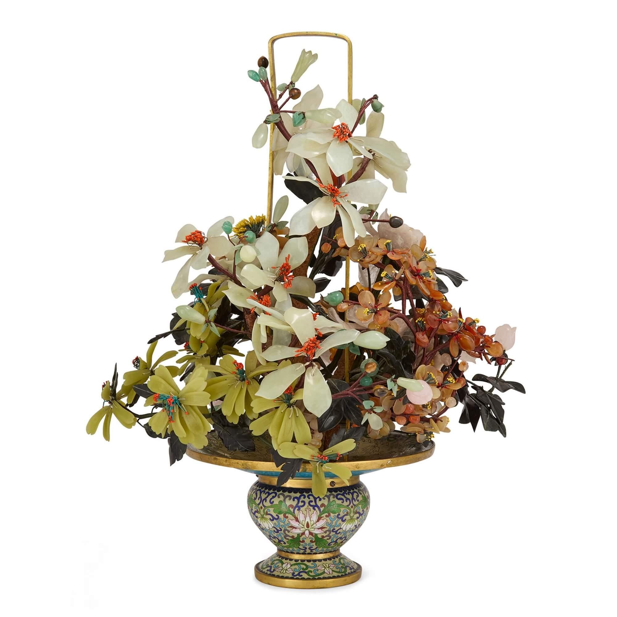 Modello di albero di fiori cinese in pietra dura e smalto cloisonné 
Cinese, XX secolo 
Altezza 54cm, larghezza 42cm, profondità 39cm

Questo affascinante Objet d'art, raffigurante un cesto riempito con una sontuosa composizione floreale, è stato