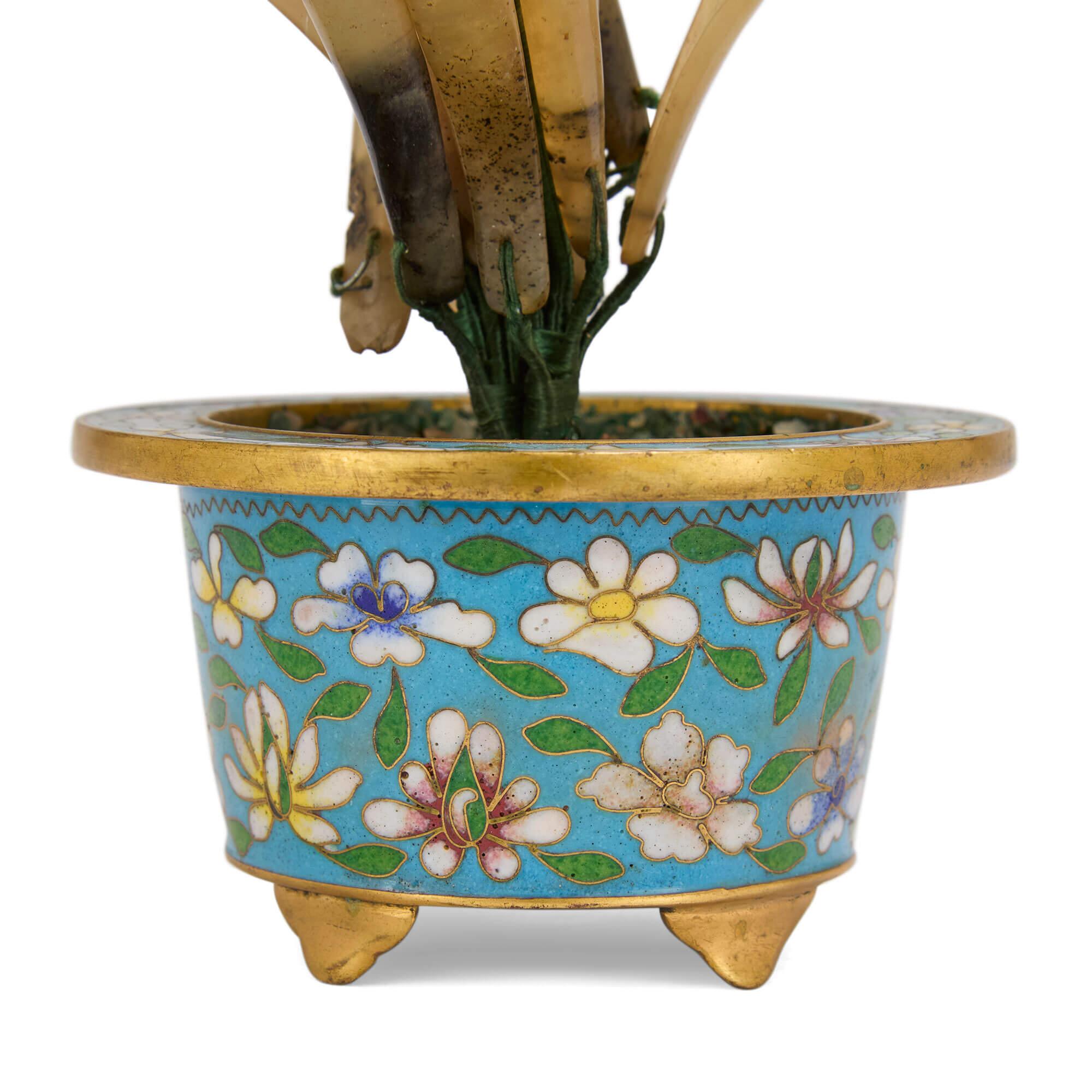 Chinese hardstone flower model in a cloisonné enamel planter
Chinese, 20th Century
Height 20cm, width 12cm, depth 9cm

This superb flower model brings together a host of precious stones, placed inside a cloisonné enamel planter decorated with floral