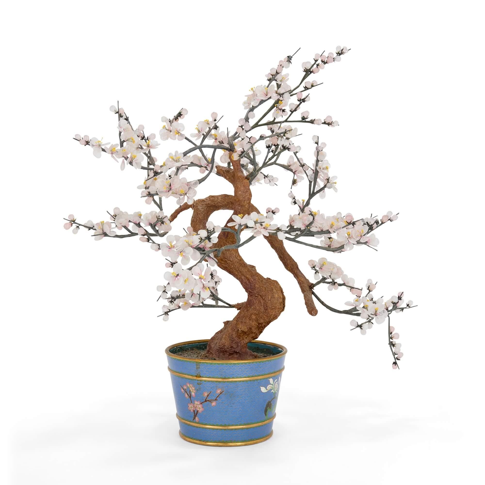 Modèle chinois en pierre dure représentant une fleur de cerisier dans un cache-pot en émail cloisonné 
Chinois, 20e siècle 
Hauteur 57cm, largeur 52cm, profondeur 40cm 

Ce modèle d'arbre exquis est fabriqué à partir d'un magnifique quartz rose, de