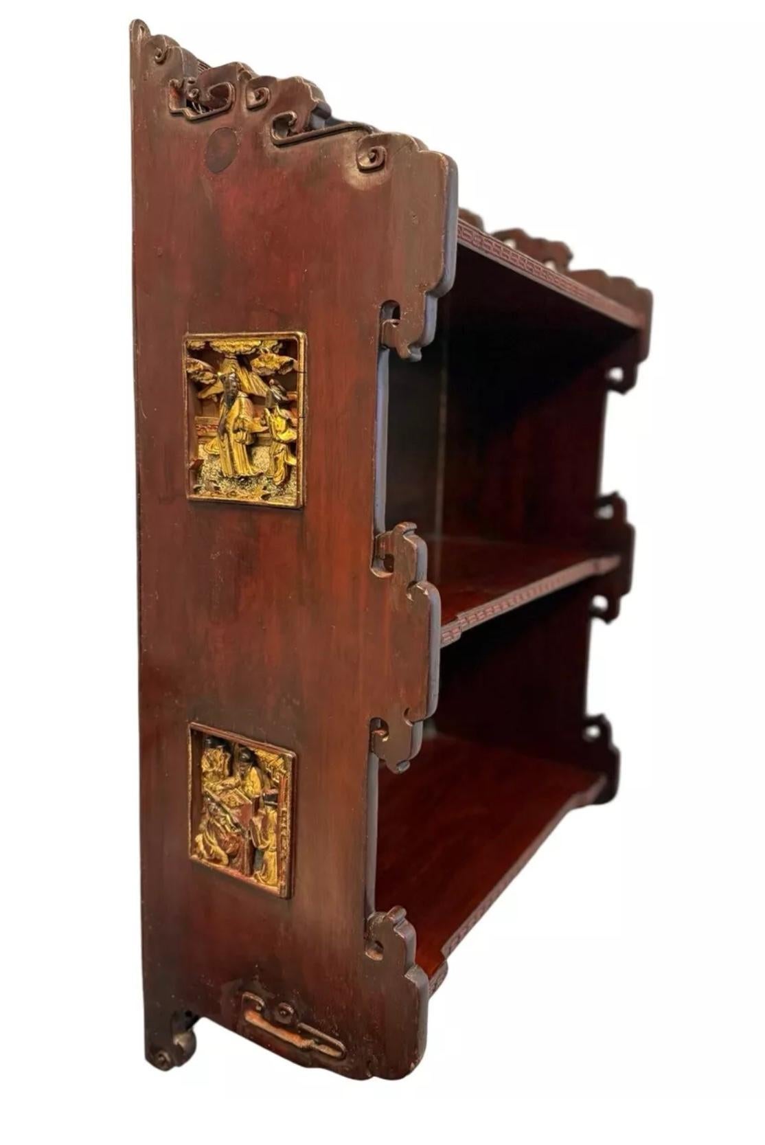 Dieses exquisite chinesische Holzregal ist eine meisterhafte Mischung aus traditioneller Handwerkskunst und künstlerischen Verzierungen und bietet sowohl funktionale Aufbewahrung als auch ein elegantes optisches Highlight. Das reiche, warm getönte