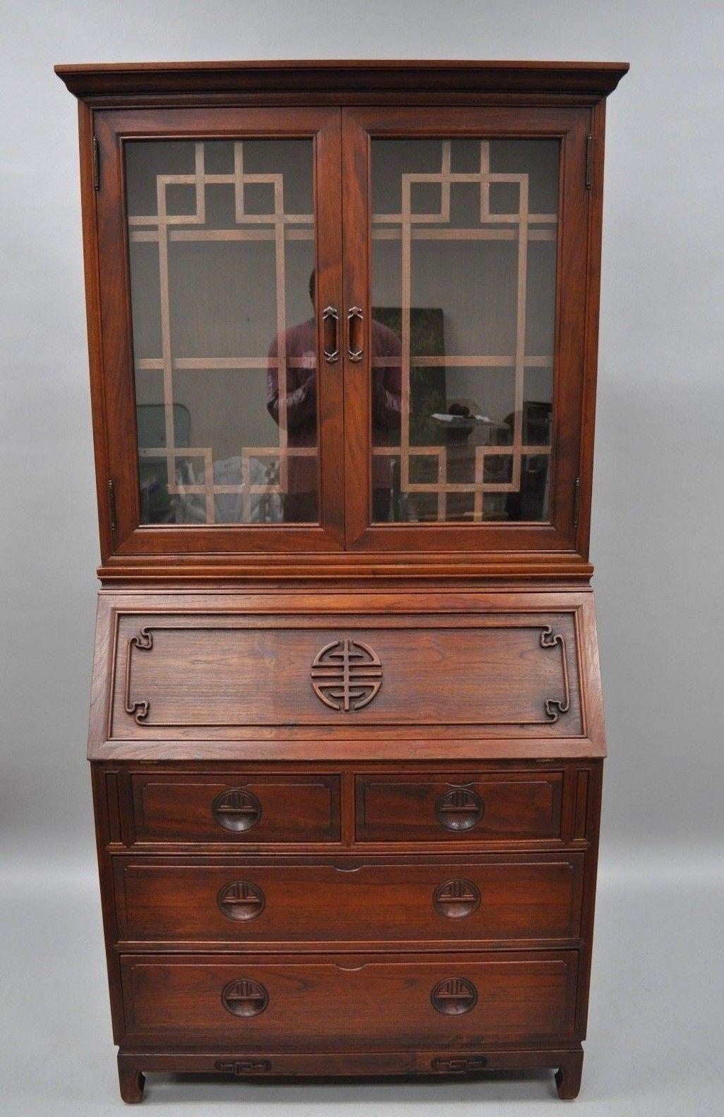 Chinese hardwood Oriental secretary desk. Item features two piece construction, carved side panels, fitted interior, beautiful woodgrain, nicely carved details, two glass swing doors with wood lattice, seven dovetailed drawers, and two adjustable
