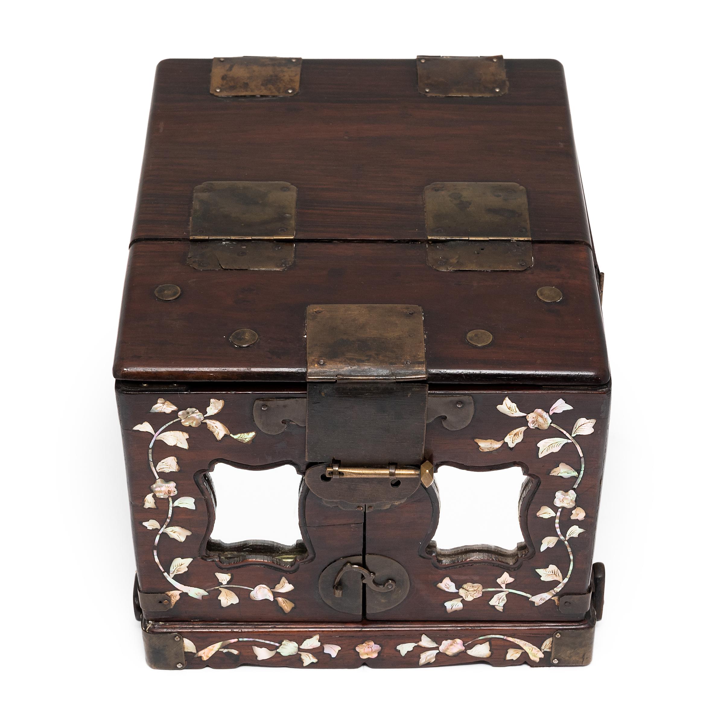 Long ago, this elegant rosewood box was used by a Qing-dynasty lady to store her favorite pieces of jewelry, each drawer filled with jades, pearls, coral necklaces, and hair pins. The front is adorned with delicate floral mother-of-pearl inlay and