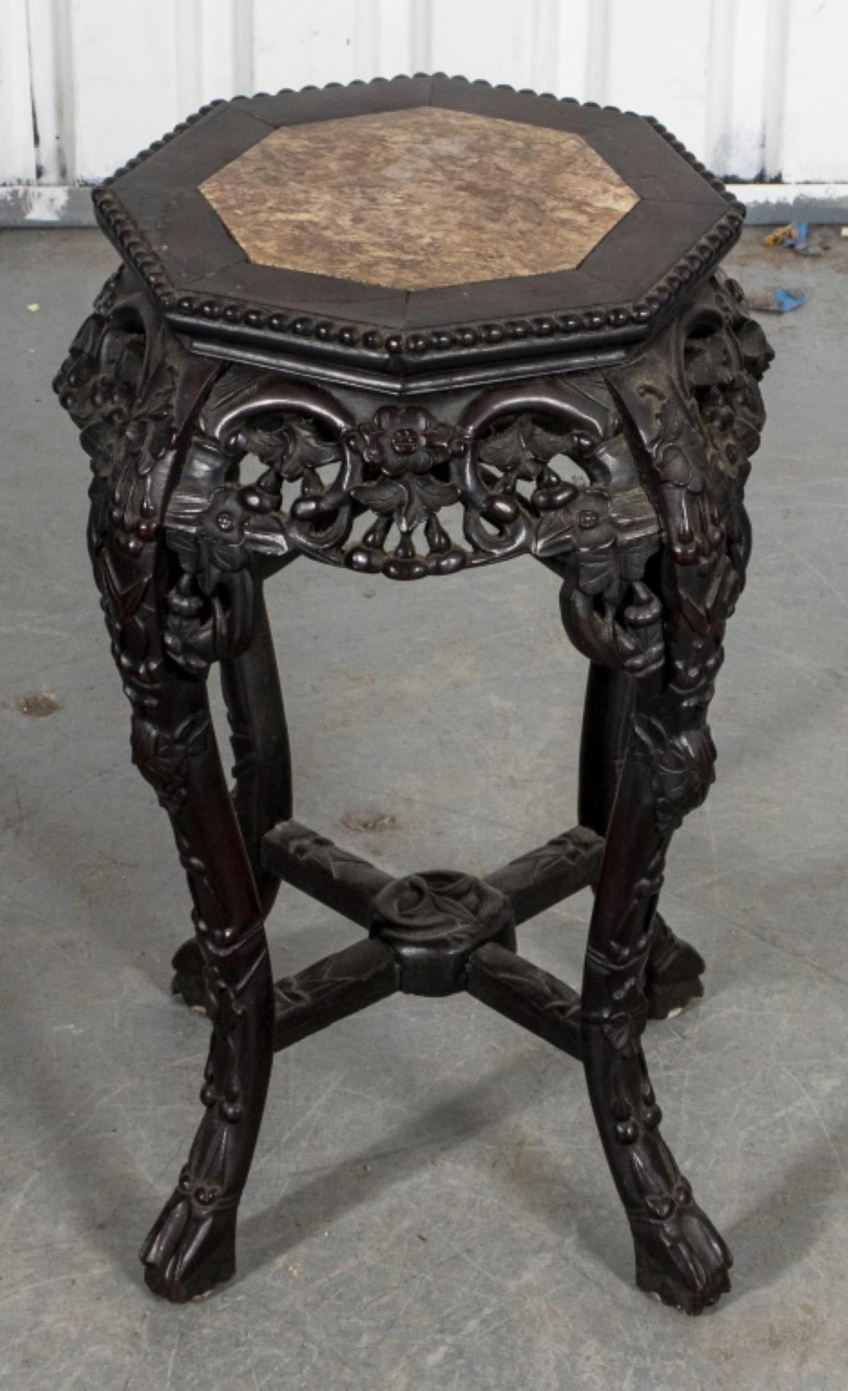 Exquisite Chinese carved hardwood jardiniere stand.

Boasting an octagonal top gracefully inlaid with a smooth marble slab.
The intricately carved frame and legs showcase a symphony of blooming flowers and delicate foliage, culminating in sturdy