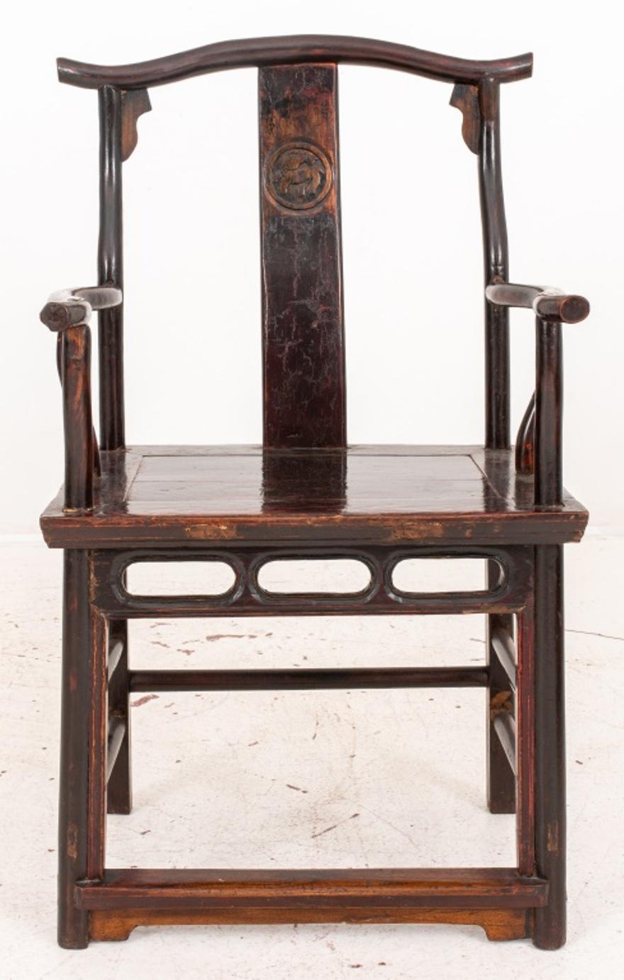 Chinese hardwood yoke-back arm chair of 'four-corners exposed' form, with shaped crest rail above the S-shaped relief-carved splat and supported on curved corner posts, the curved arm rails above curved struts and extending beyond the front rails,