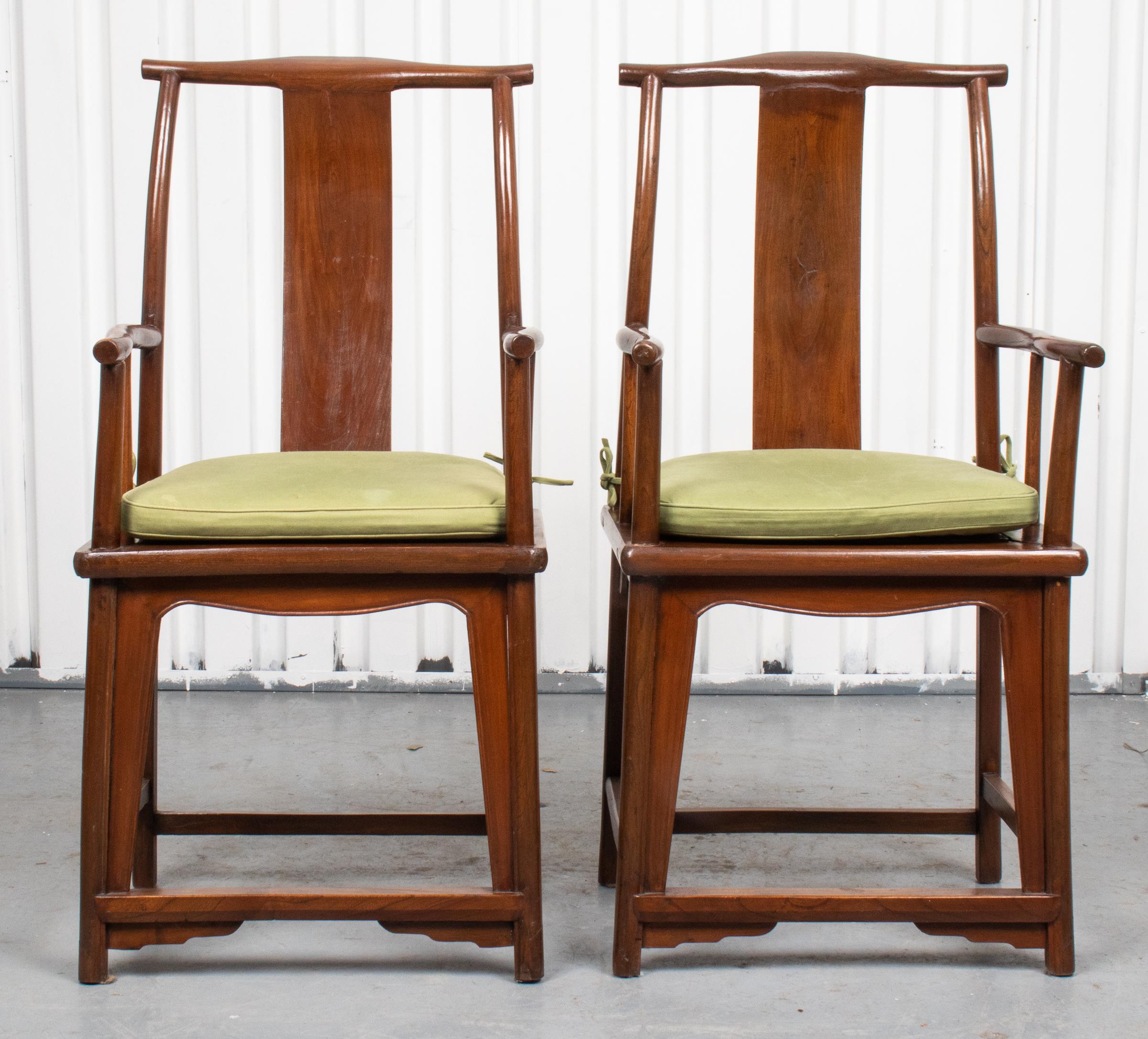 Pair of Chinese hardwood yoke back scholar's chairs, the frames with gently canted crest rail and arms around simple yokes and plain inset seats. Measures: 42.5” H x 20” W x 19” D.