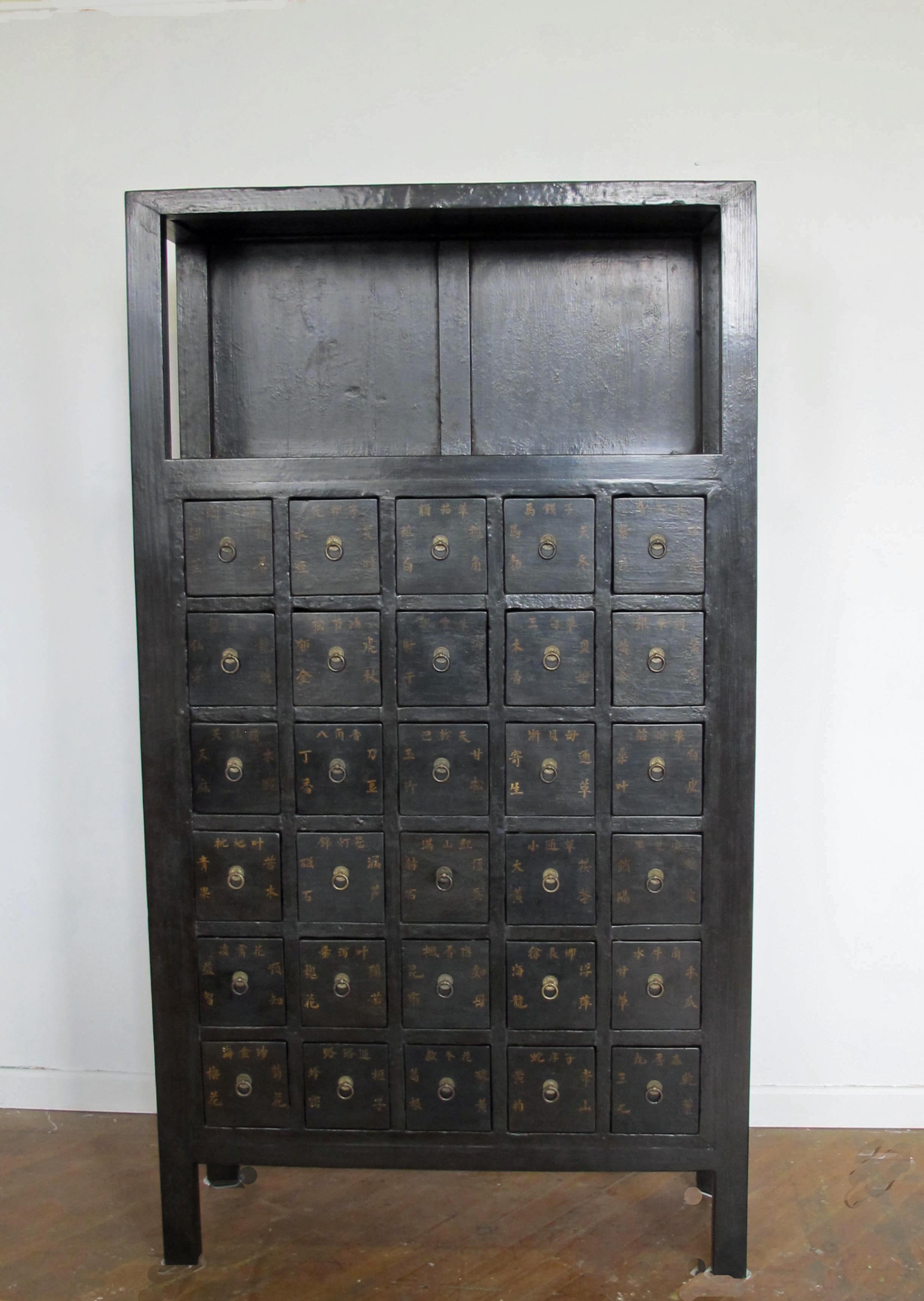 This cabinet with 30 drawers was used to hold herb medicines in a Chinese apothecary centuries ago. The name of each herb medicine is written on the door. It shows a nice patina in dark chocolate color. This exotic apothecary cabinet will not just