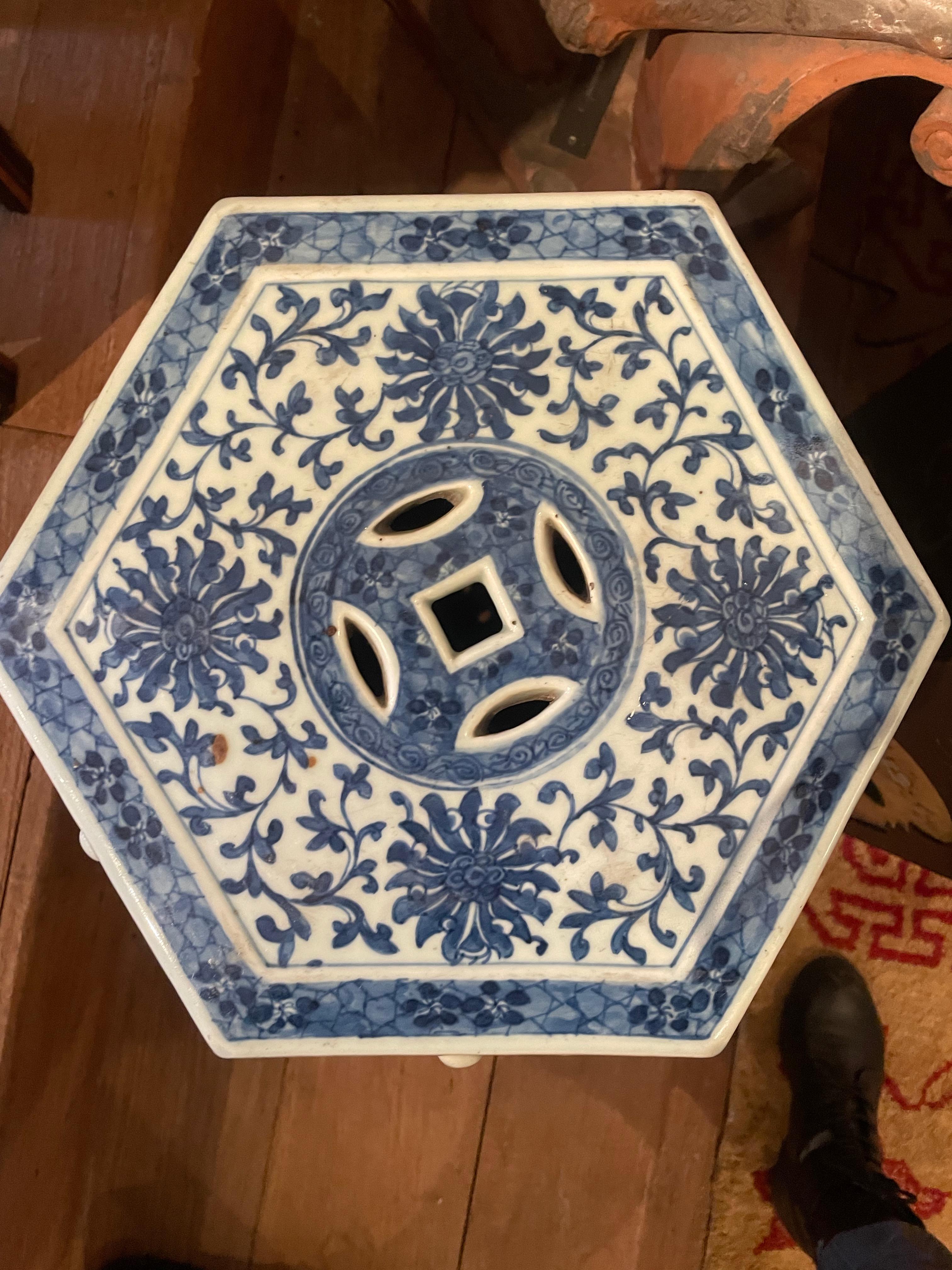 A hexagonal Chinese blue and white porcelain garden seat, decorated with scrolling lotus c.1880. The all-over blue on white decoration to the top and each side, interspersed with raised circular detailing with pierced coin motifs on opposing sides.