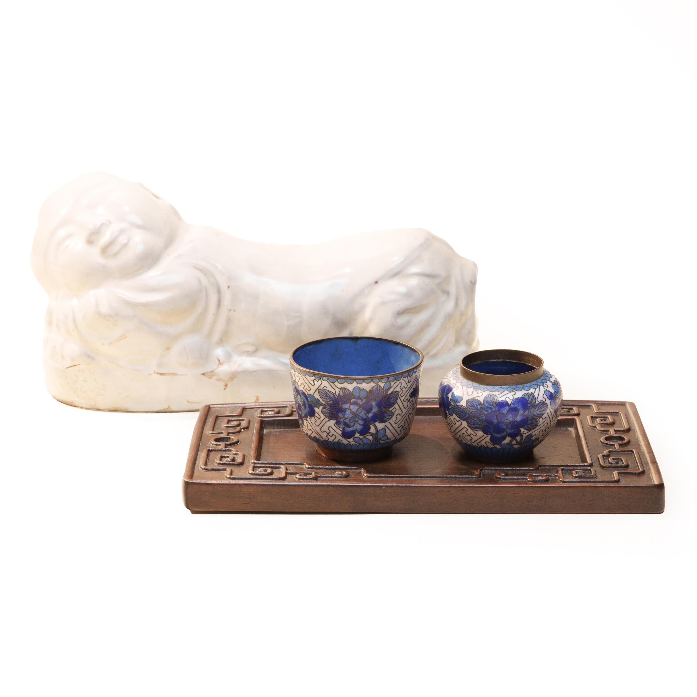 Per mantenere intatta la sua elaborata acconciatura durante il sonno, una donna benestante della dinastia Qing usava questo poggiatesta in ceramica come cuscino. Questo poggiatesta ha la forma di un bambino, un motivo comunemente chiamato 