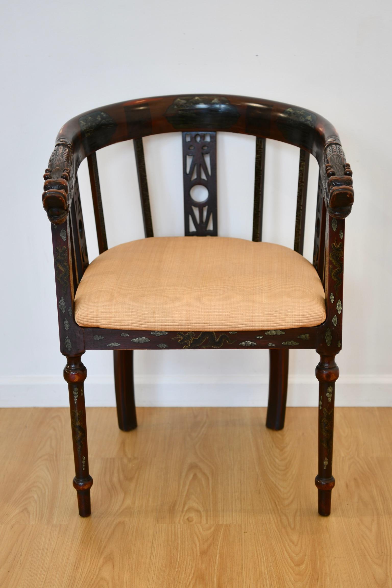 Chinese carved and polychrome painted horseshoe back armchair with dragon head arms, floral and shell accents, and cushion. Dimensions: 32