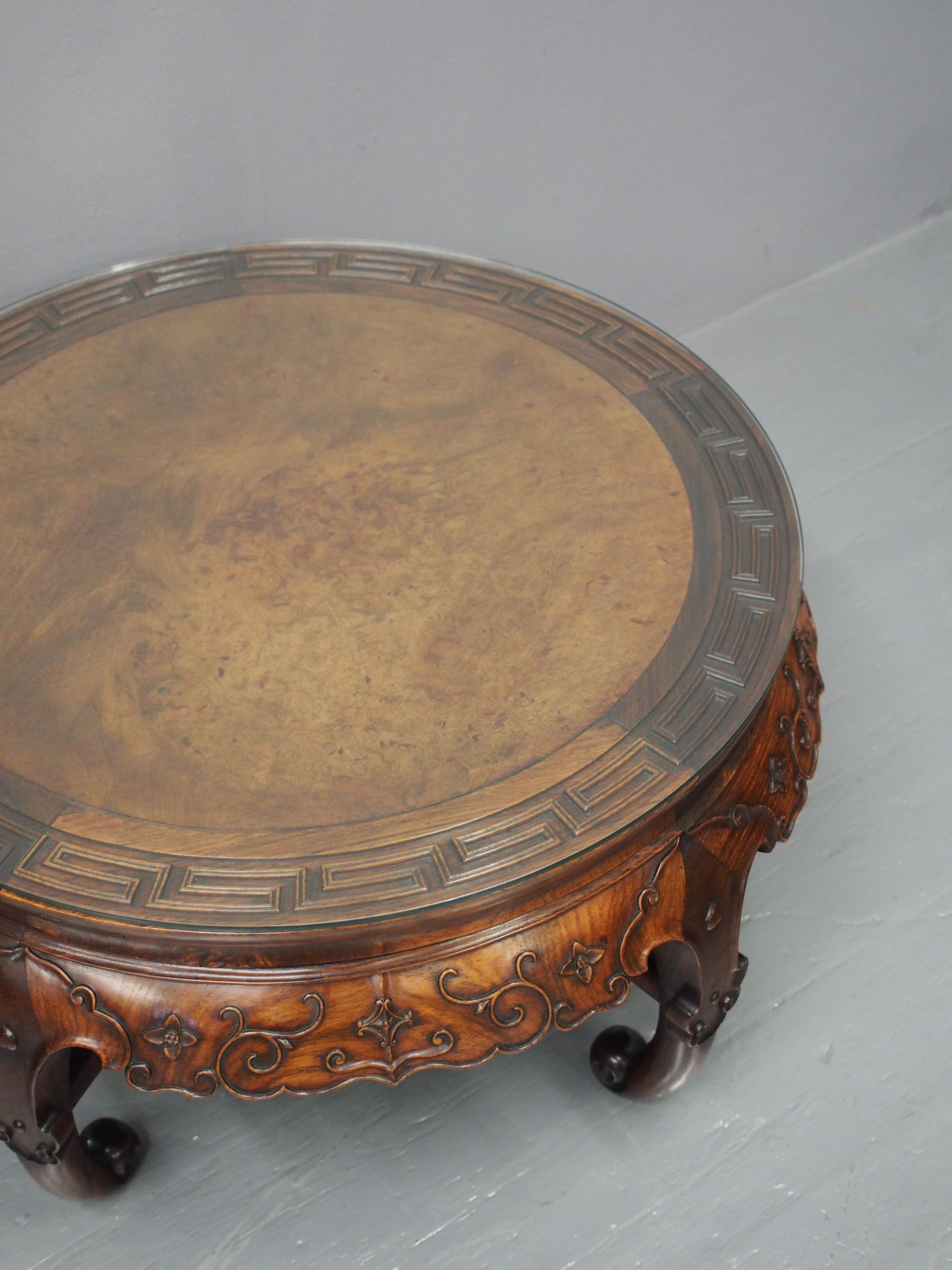 Qing dynasty Chinese Huanghuali low table, circa 1900. With burr wood centre, carved border and an ogee section beneath it with a flared apron with Chinese motifs and foliate carving. Standing on classic Chinese shaped legs with scrolling toes,