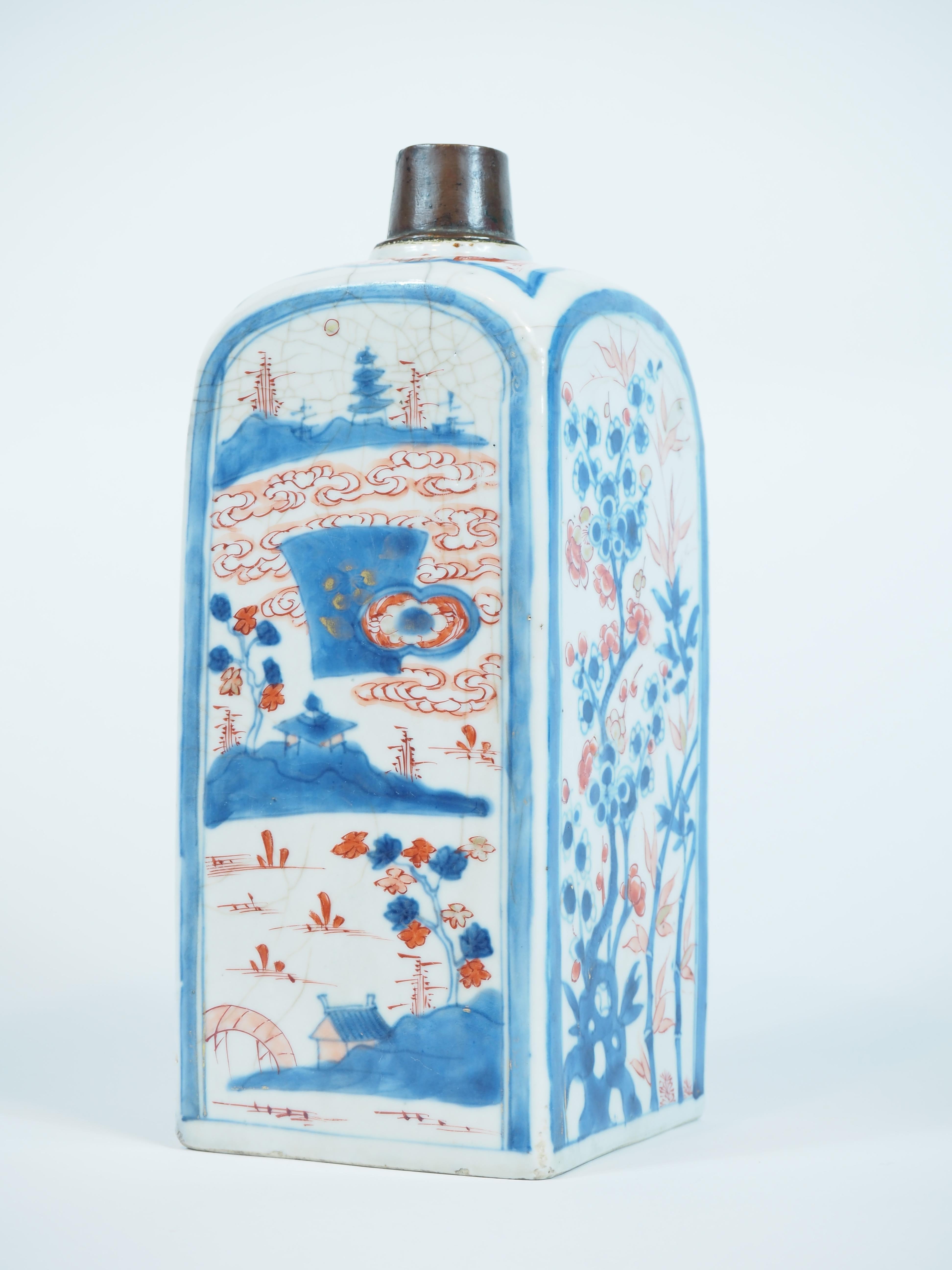 Chinesische Imari-Flaschenvase, viereckig, Kangxi-Periode (1662-1722), dekoriert in Blau und Rouge de Fer mit Flusslandschaften, Blumendekor und Bambus.

Höhe: 25 cm.

Zustand: einige Haarrisse, Craquelé, Ausguss beschädigt und mit Kragen.