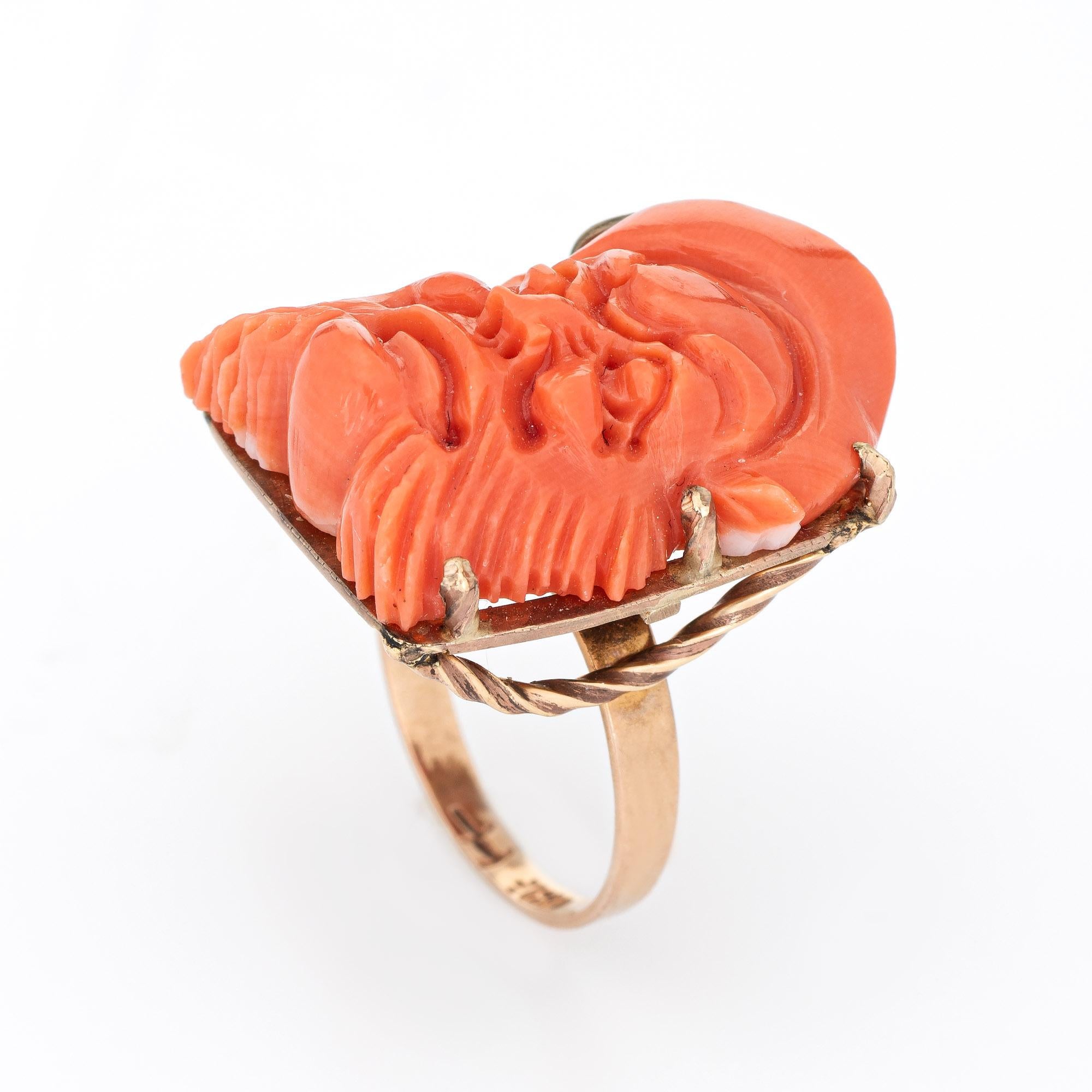 Finely detailed carved coral ring (circa 1950s to 1960s) crafted in 14 karat yellow gold. 

Carved coral measures 24.5mm x 20mm. The coral is in very good condition and free of cracks or chips. 

The coral is carved with the face of one of the