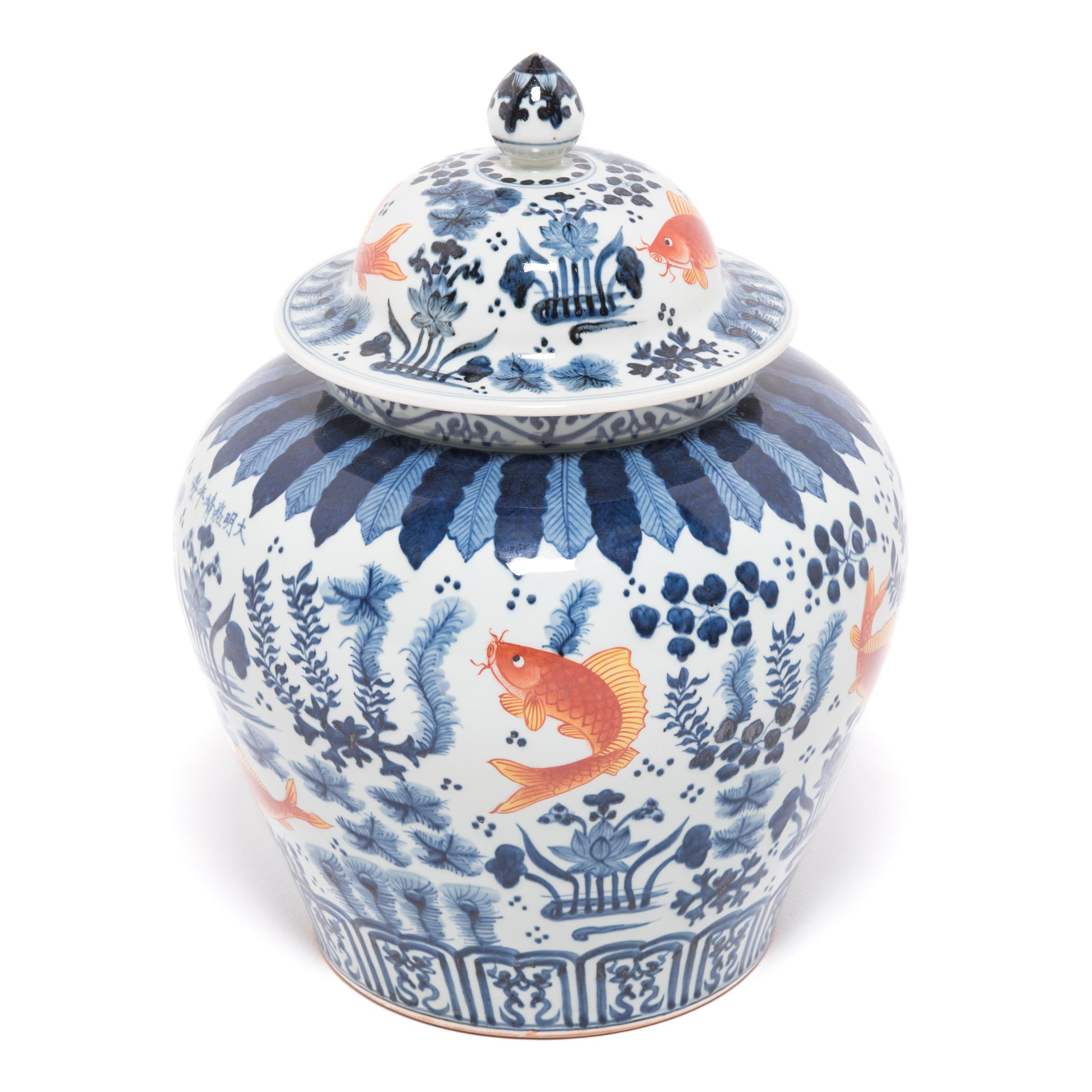 A modern artisan applied the vibrant copper and indigo imagery before firing, a process of under glazing that was developed during the Song dynasty. The finely painted symbols, fish, lotus pods, and underwater plants hold deeper meaning in Chinese