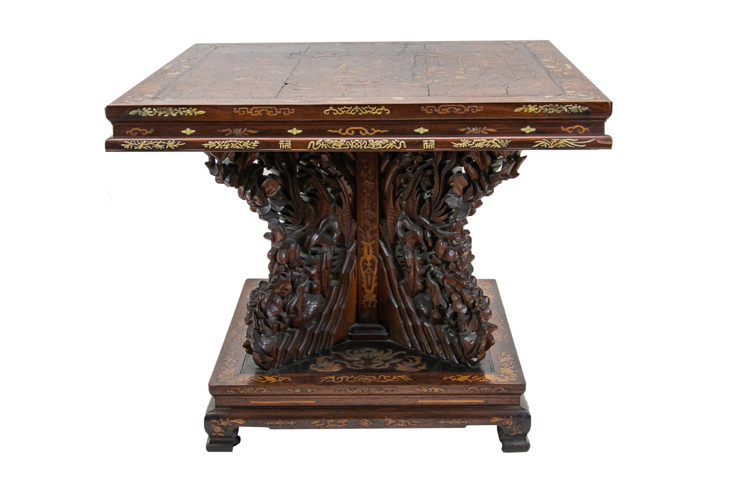 Chinese inlaid center table, is composed of rosewood and walnut. It is profusely inlaid with pagodas, human figures, birds, deer, water buffalo, and tree arabesques. It is inlaid with satinwood and bone. The legs on the base are in a cross