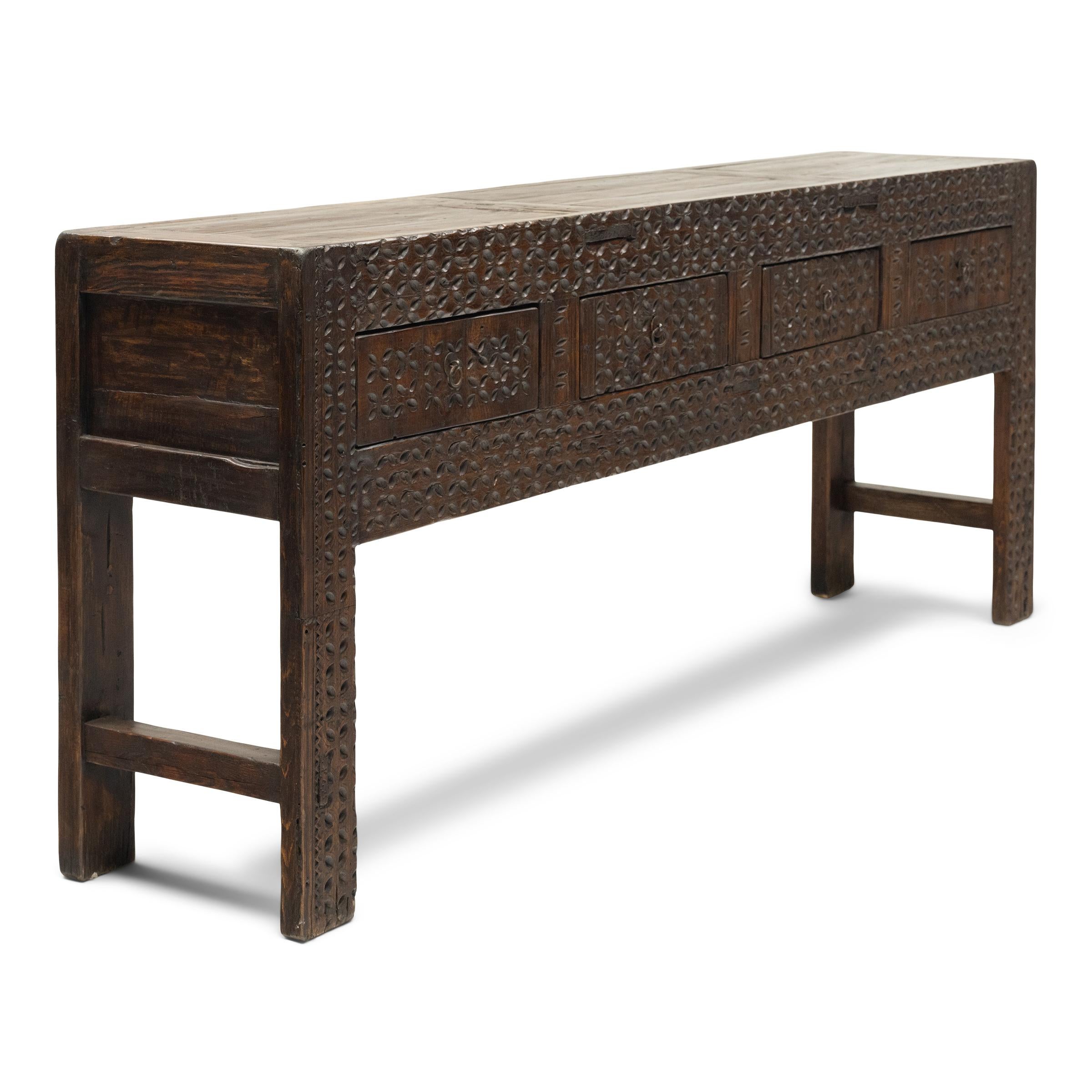 This rustic, four-drawer altar coffer balances modern simplicity with humble, timeworn materials. Attributed to artisans of Xinjiang province in Western China, the sideboard is crafted of reclaimed pine with mortise-and-tenon joinery and richly