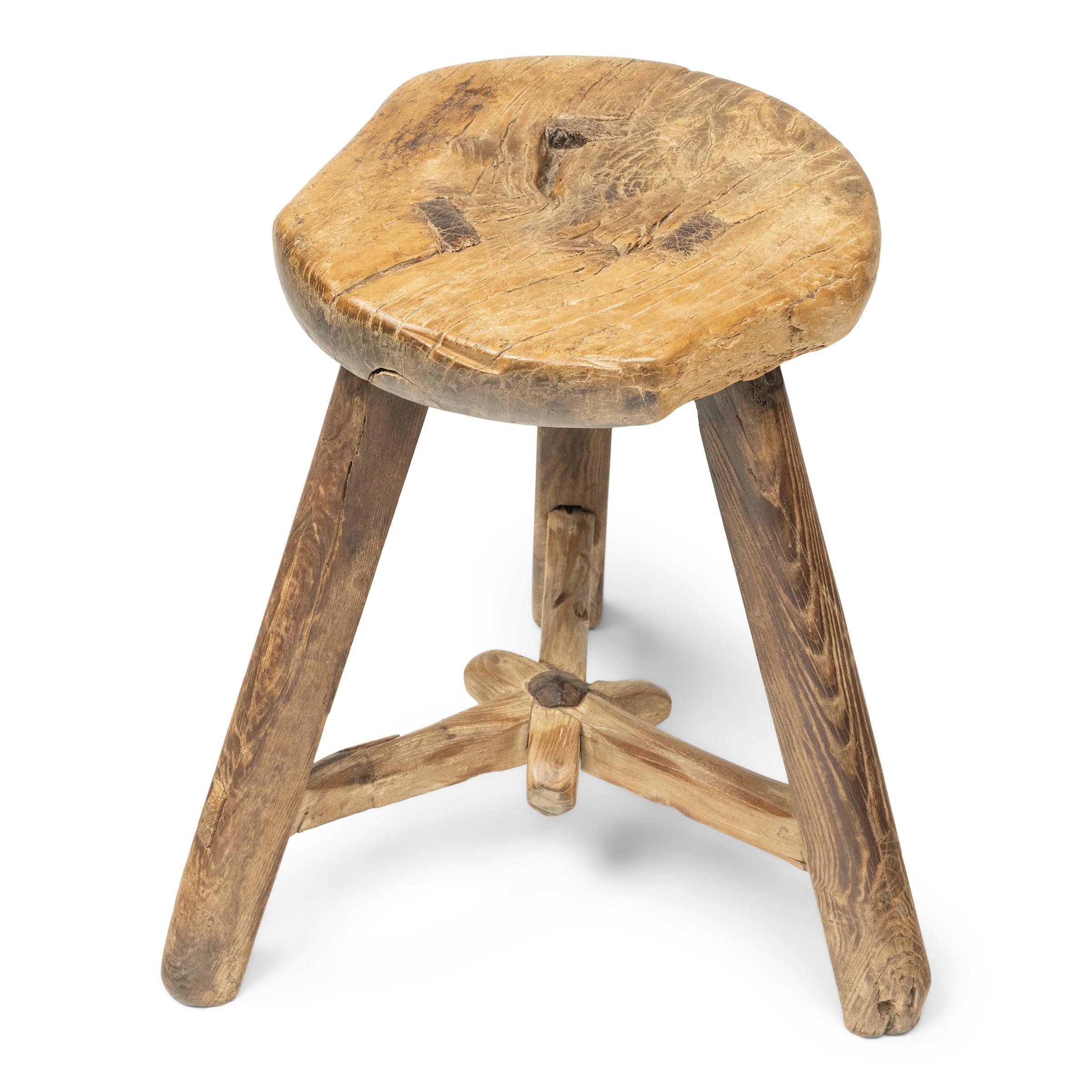 Fechado a principios de siglo, este taburete provinciano se habría utilizado en una casa con patio como asiento versátil para el día a día. Aparentemente sencillo, el taburete de madera está diseñado con un asiento redondo y tres patas separadas