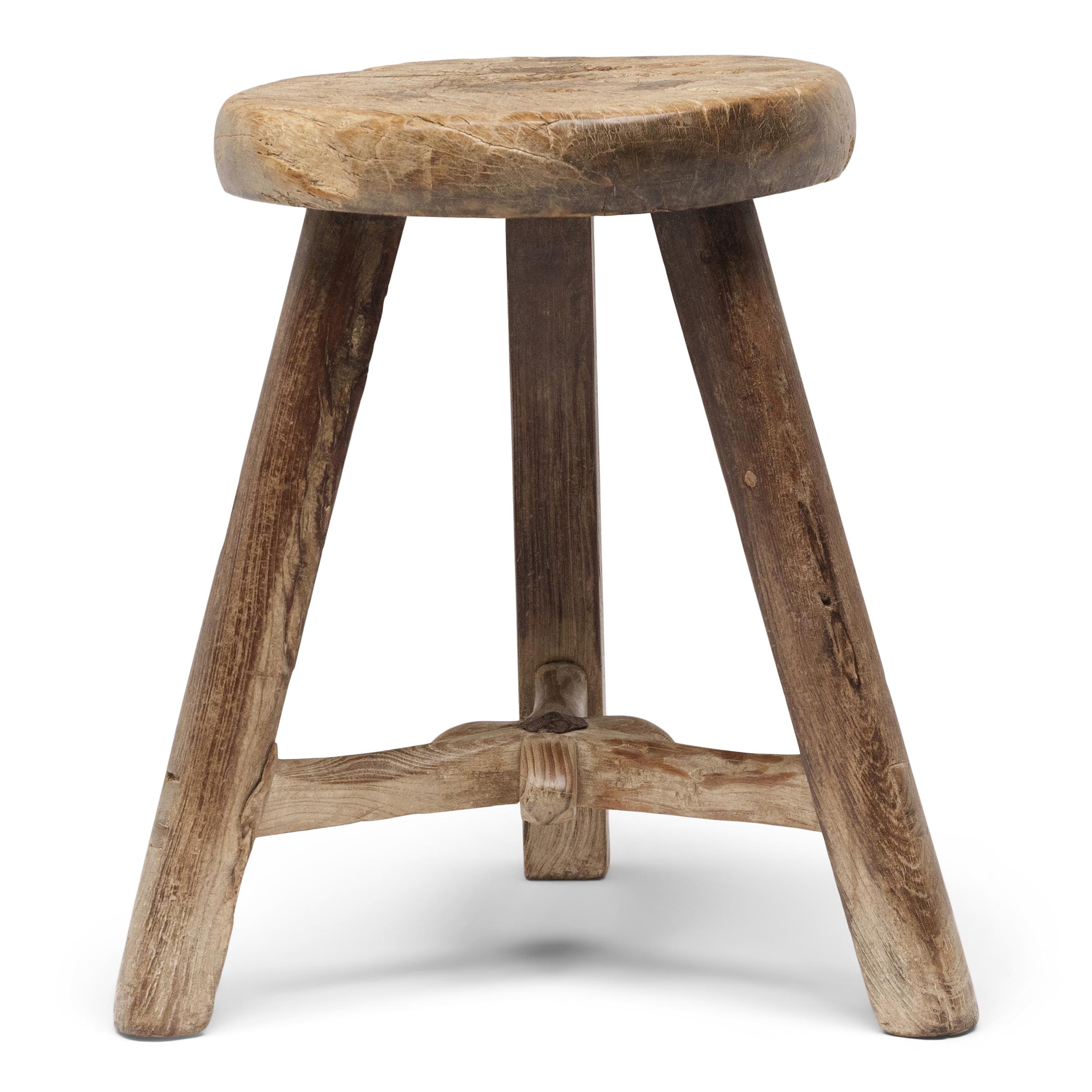 Fechado a principios de siglo, este taburete provinciano se habría utilizado en una casa con patio como asiento versátil para el día a día. Aparentemente sencillo, el taburete de madera está diseñado con un asiento redondo y tres patas separadas