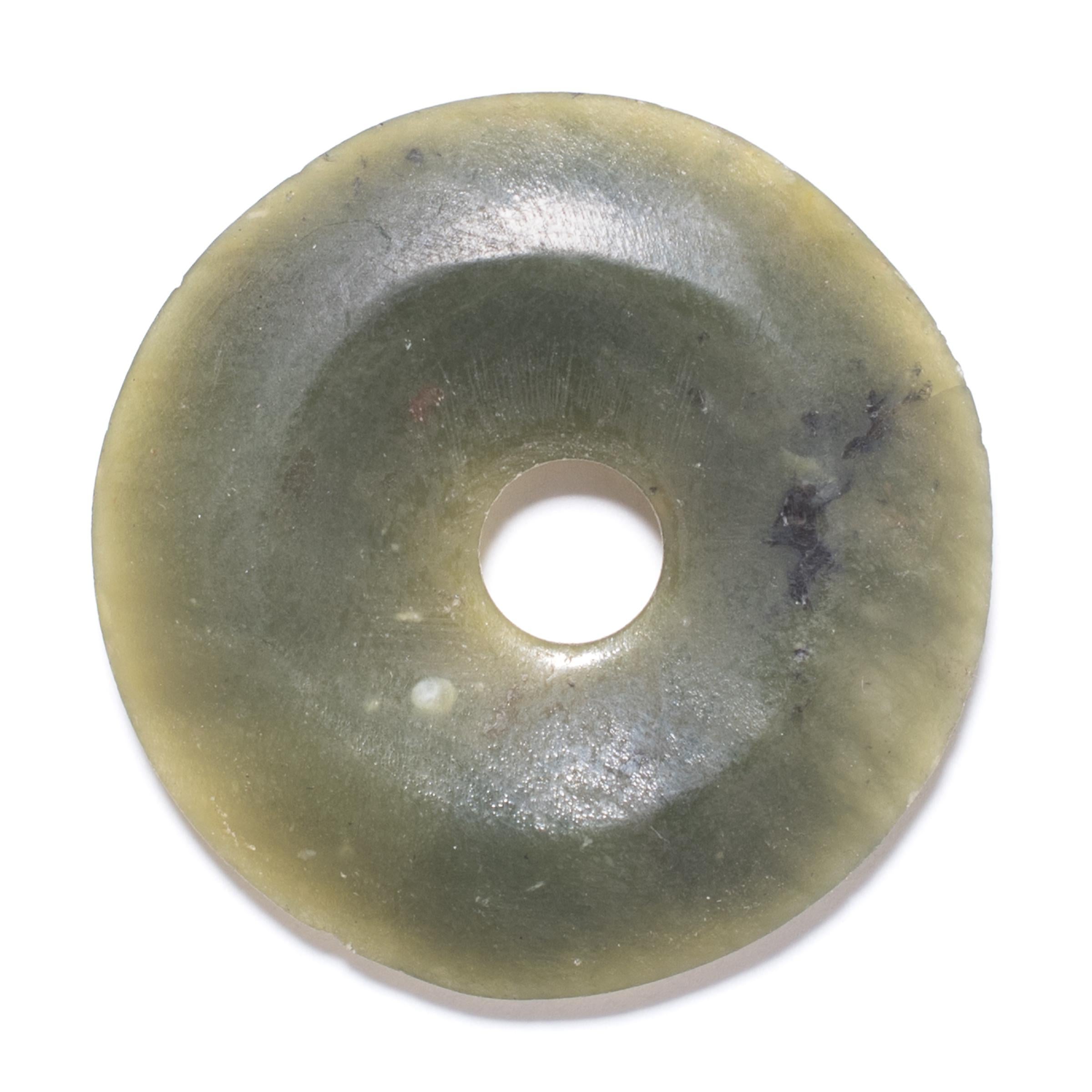Bi discs have been found in the tomcbs of ancient Chinese emperors and aristocrats, although their function and significance remain unknown. Shaping this hard stone takes considerable skill. An artisan patiently rubs the surface with sand to give