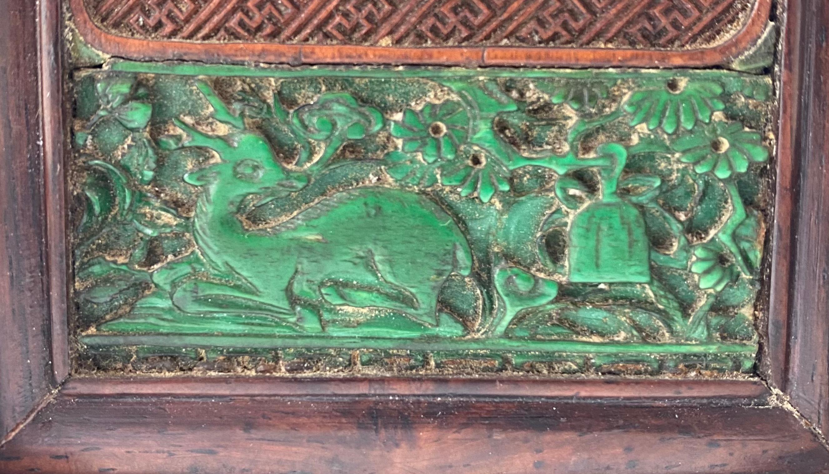 A small Chinese table screen, 19th century, Qing dynasty. The framed, detachable screen consisting of a boxwood panel, finely carved with Shoulao, the God of Longevity, holding a basket of peaches, whilst standing on a cloud, with a recumbent deer